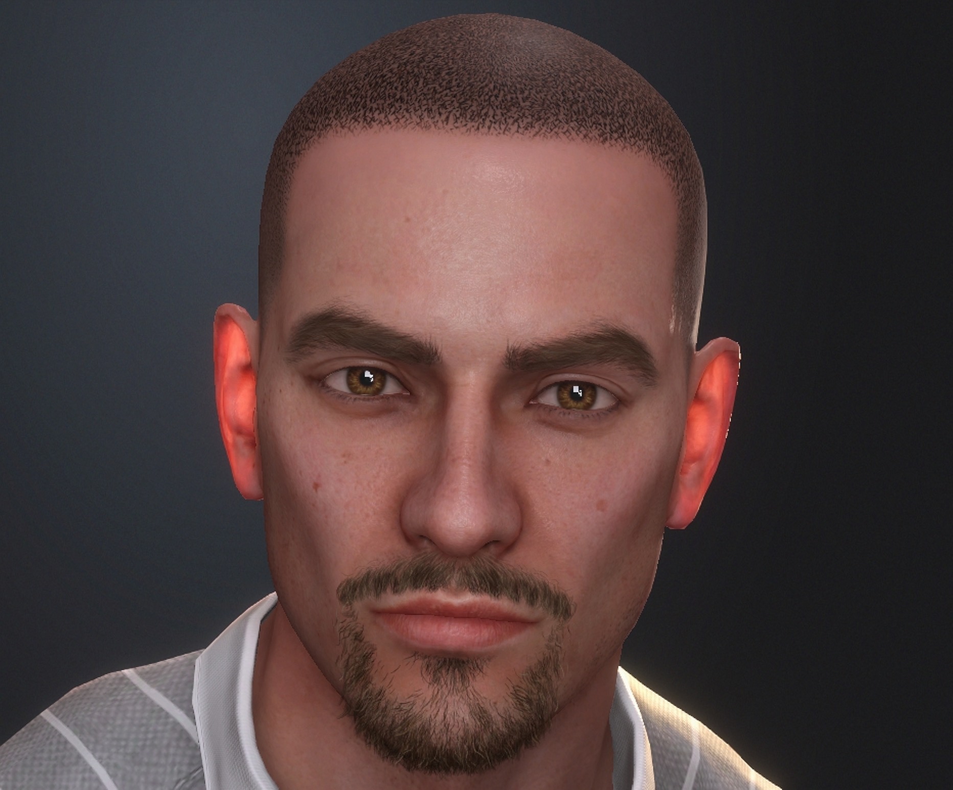 Close-up portrait of a man with short hair and facial hair, looking directly at the camera, dark background.