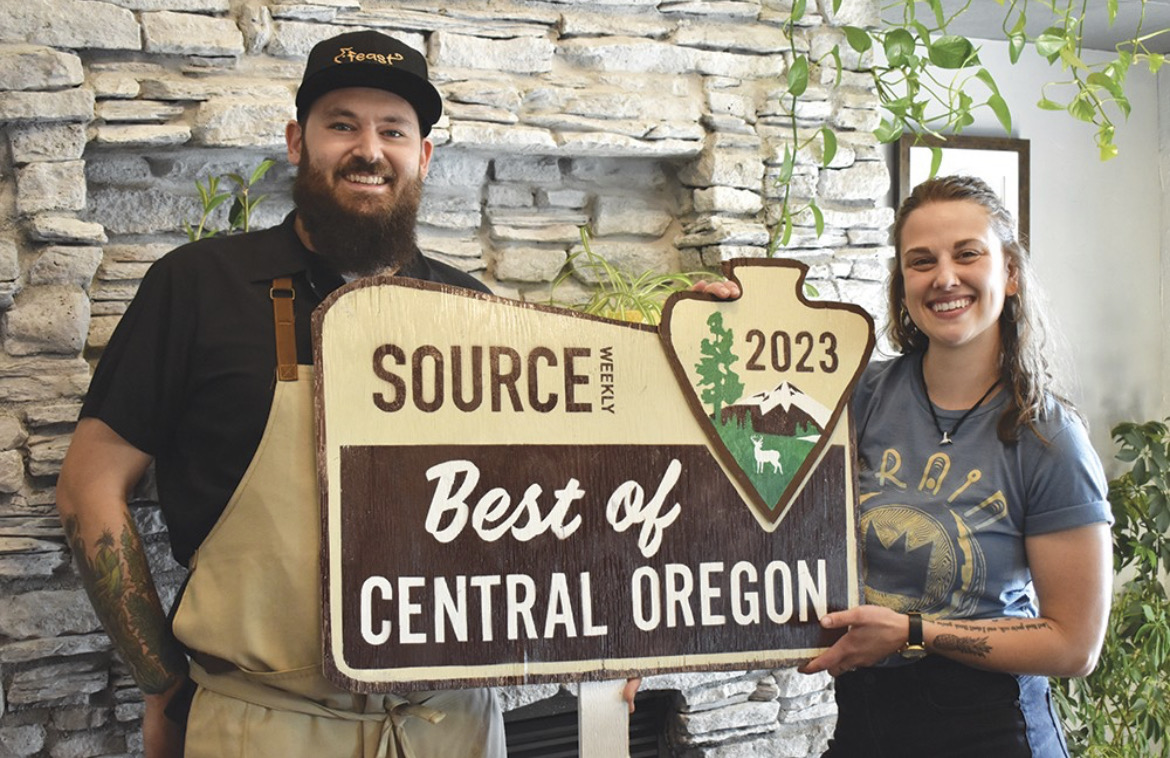 Two people holding a sign that reads