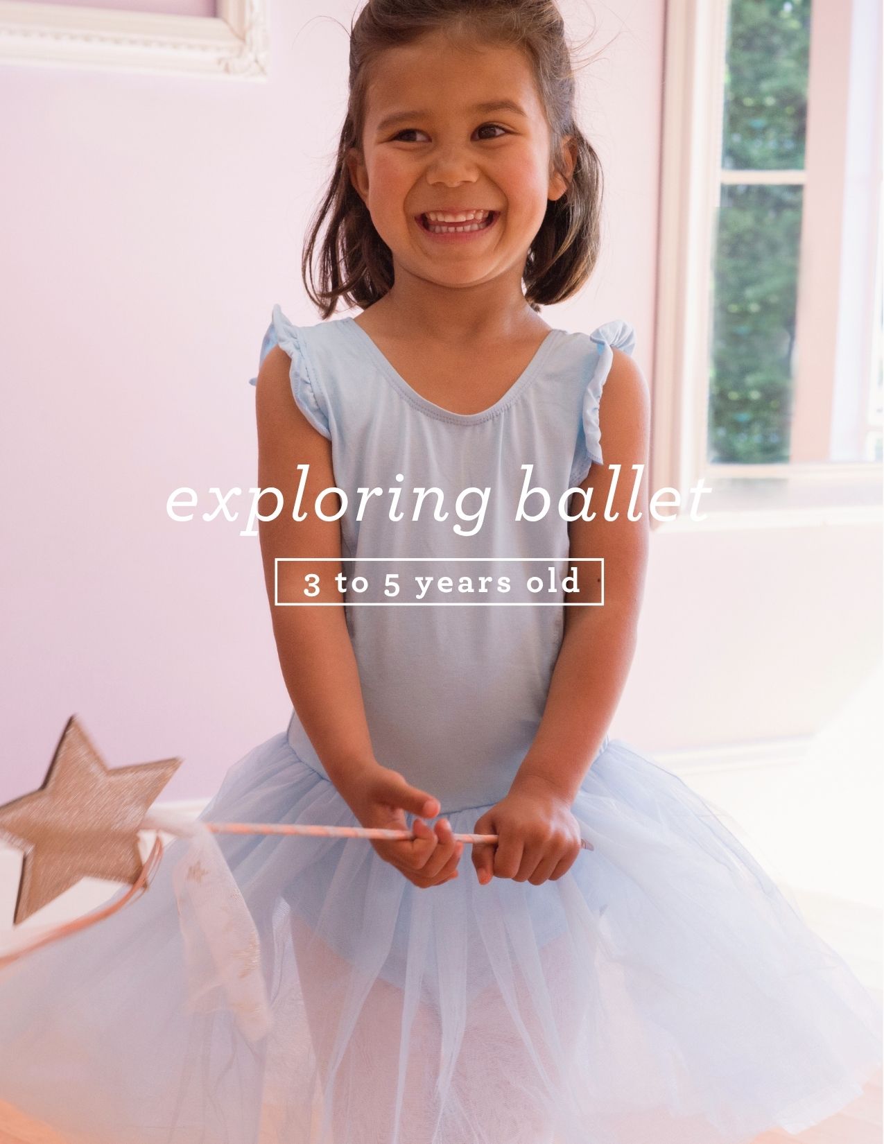 Young girl in ballet costume smiling, holding a star-shaped wand, in a bright room with windows.