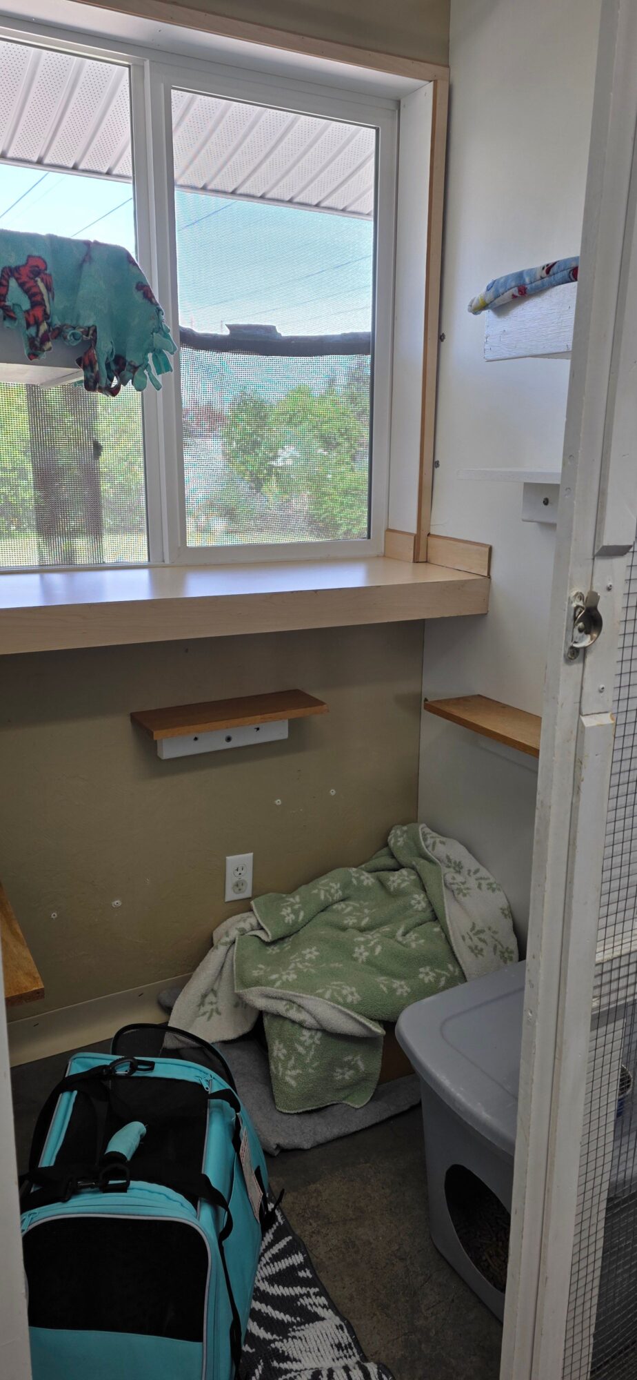 Laundry area with a washing machine, laundry basket, and a window showing outdoor scenery.