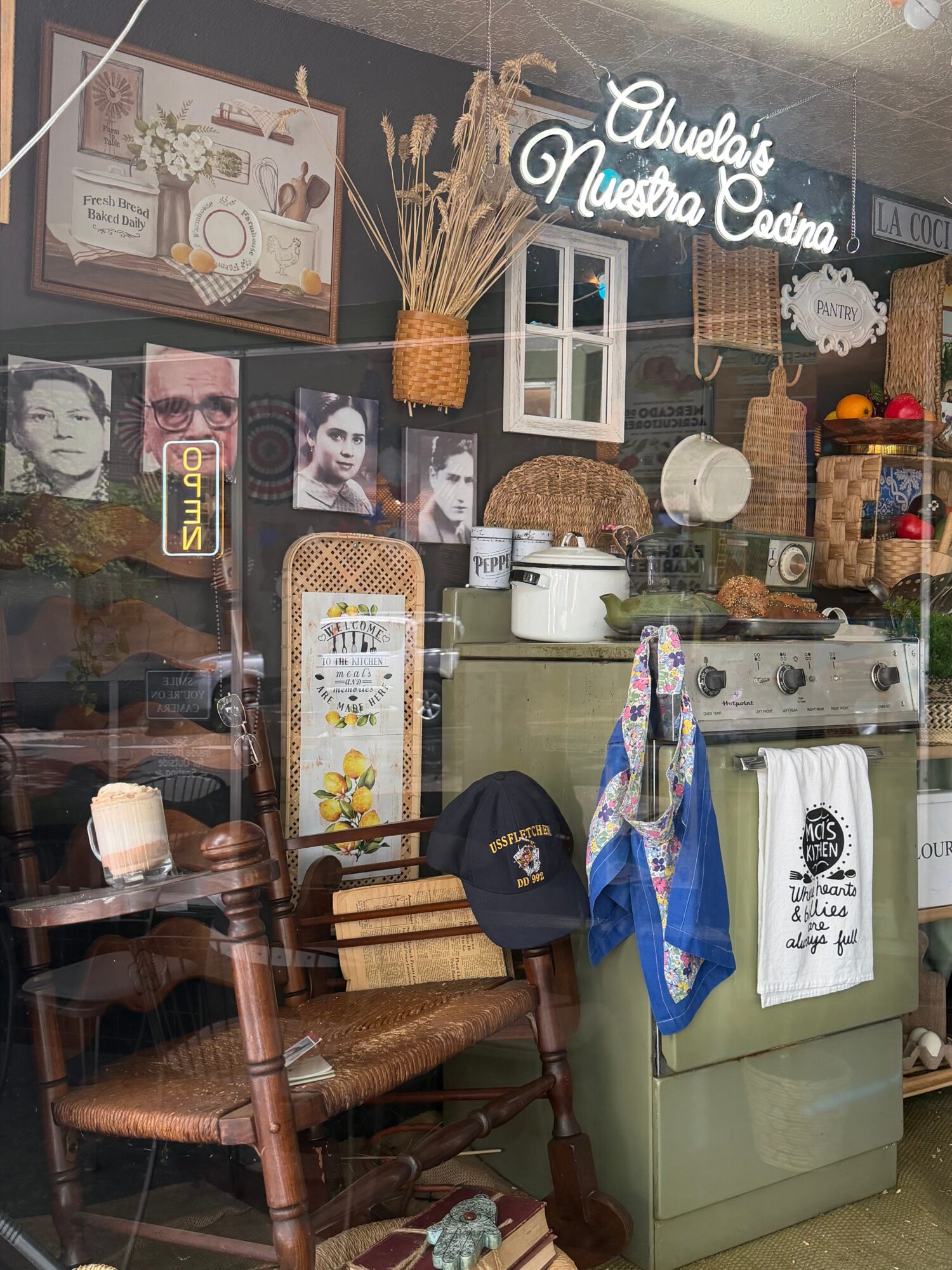 Interior of a cozy space with vintage decor, photos, a sign, and various household items.