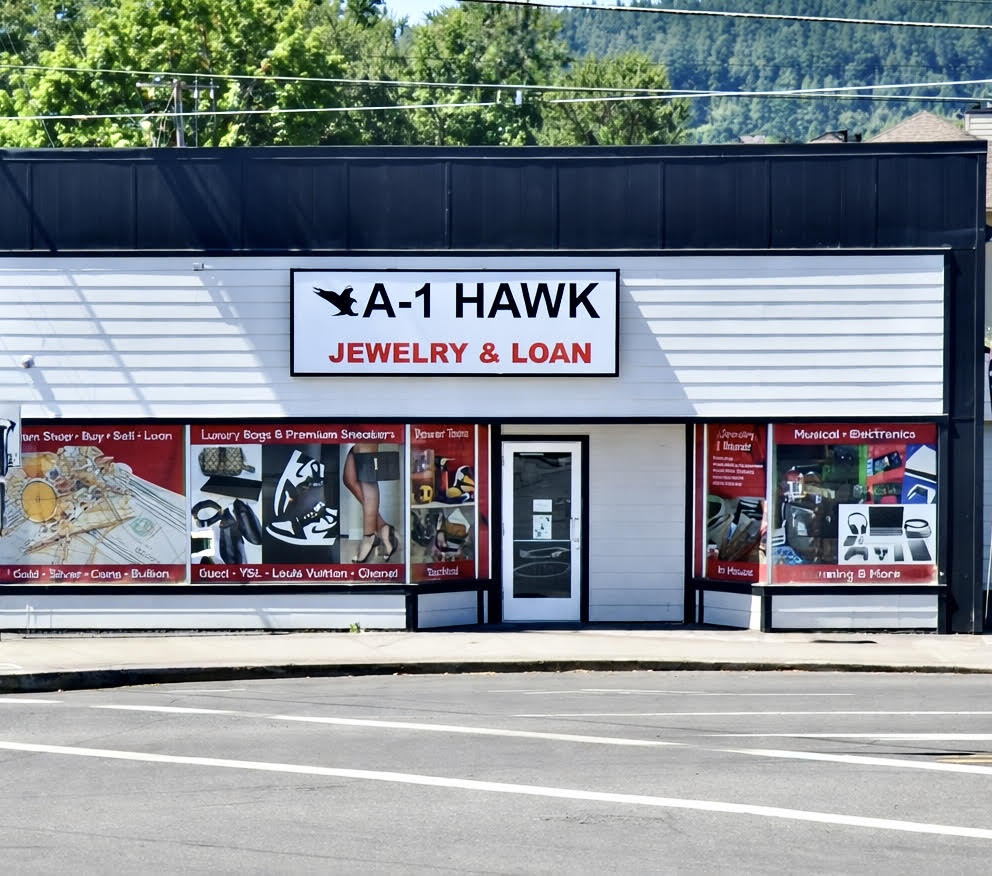 Storefront with sign reading 'A-1 HAWK JEWELRY & LOAN' and window displays of jewelry and electronics.