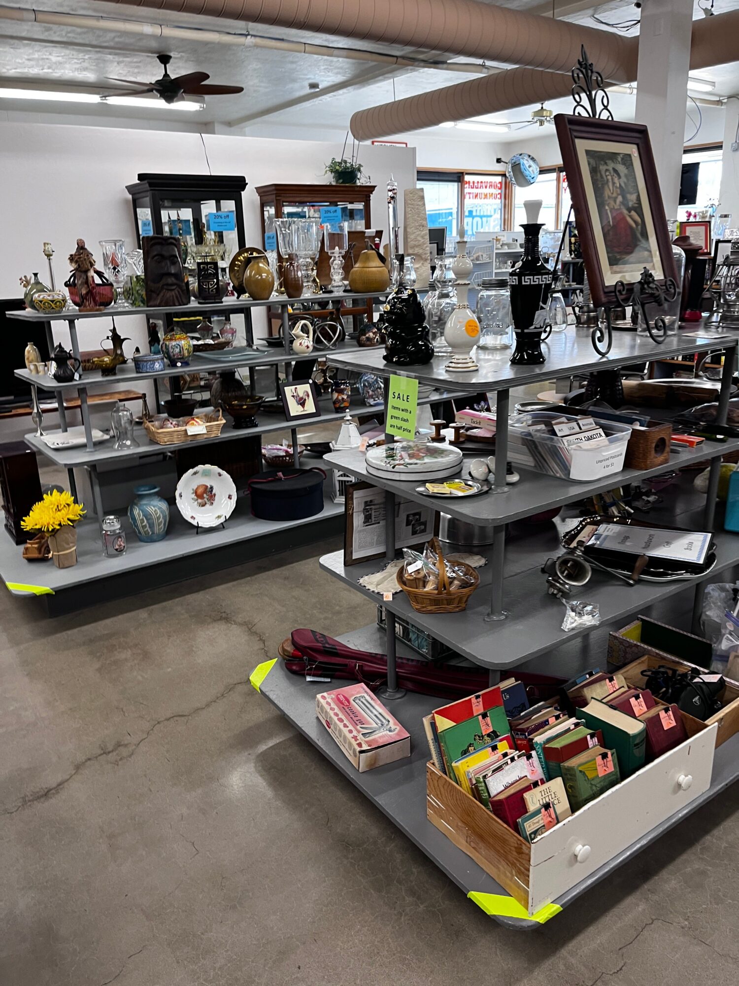 Display table with various decorative items, picture frames, and small accessories in a store.
