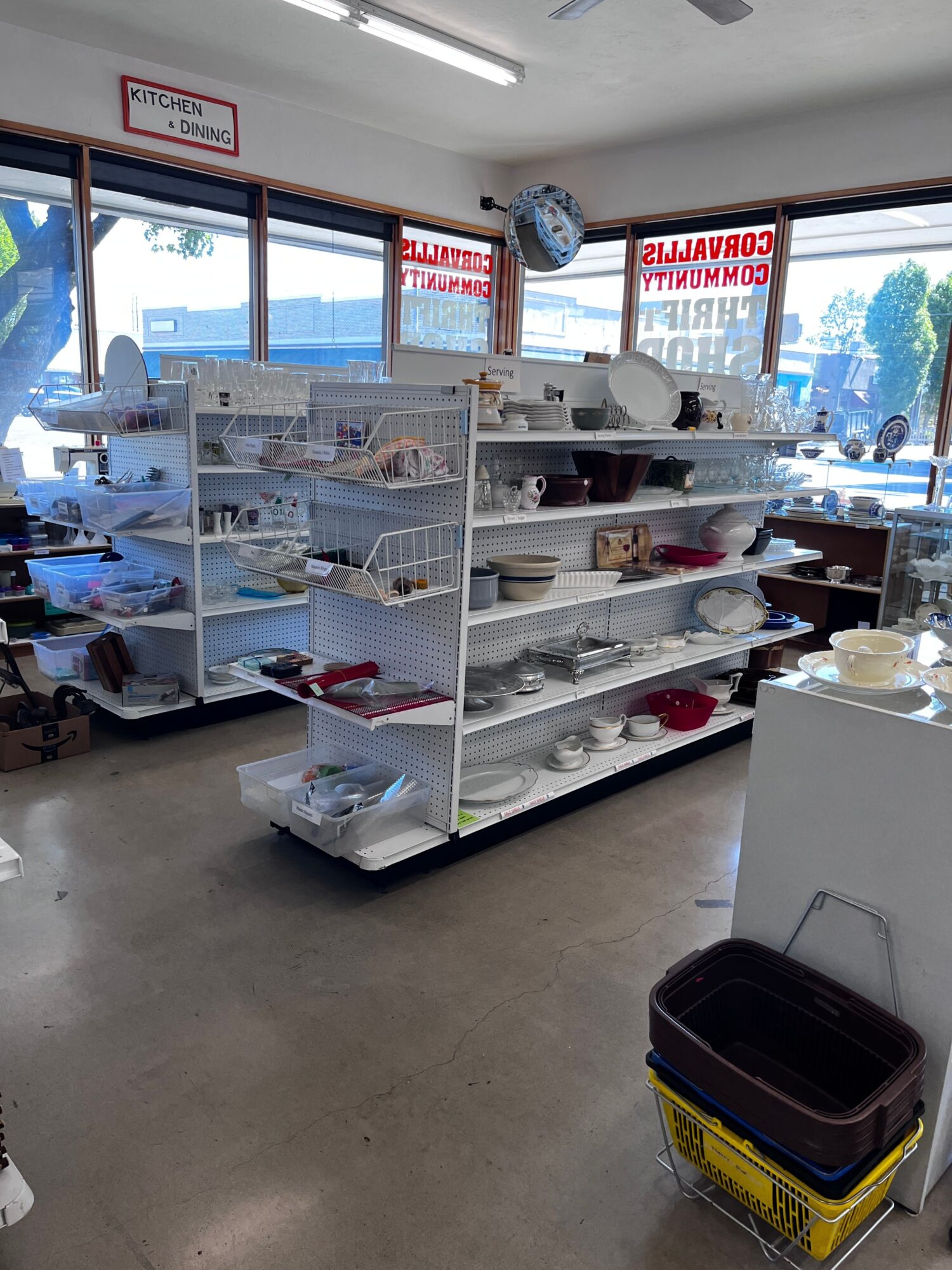 Display case with various items inside, store interior with windows, and a yellow and black toolbox on the floor.