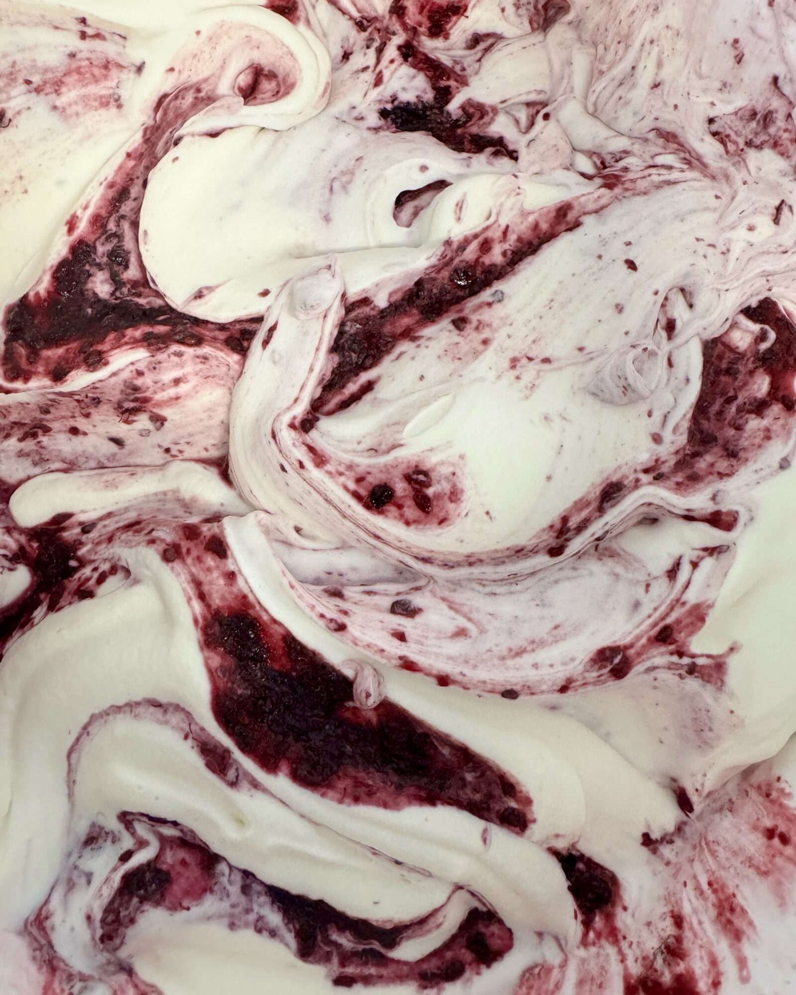 Swirling mixture of white and dark red colors with marbled patterns.