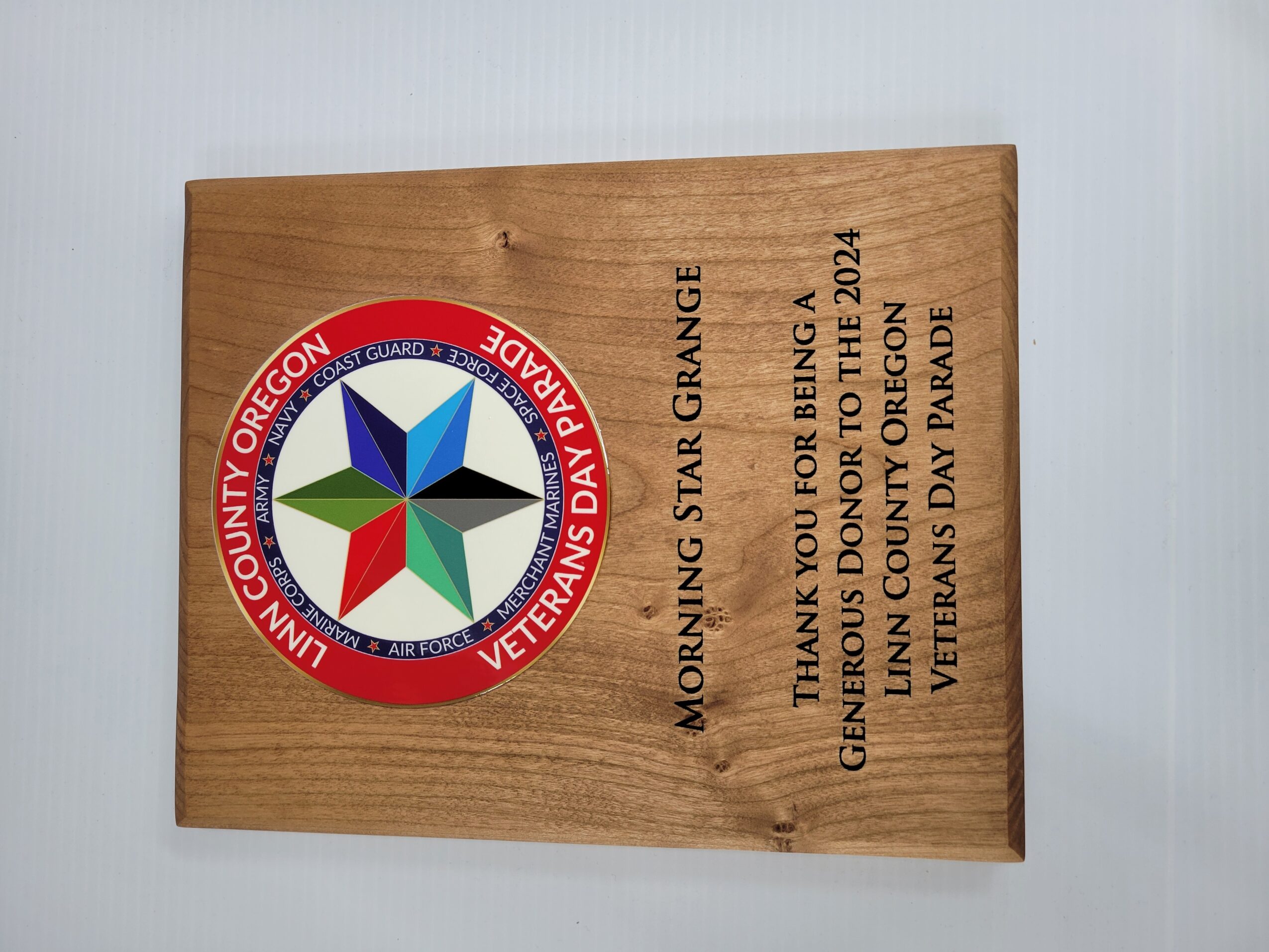 Wooden plaque with a circular emblem and text thanking for being a veteran, dated 2024, from Lincoln County Oregon Veterans Day Parade.