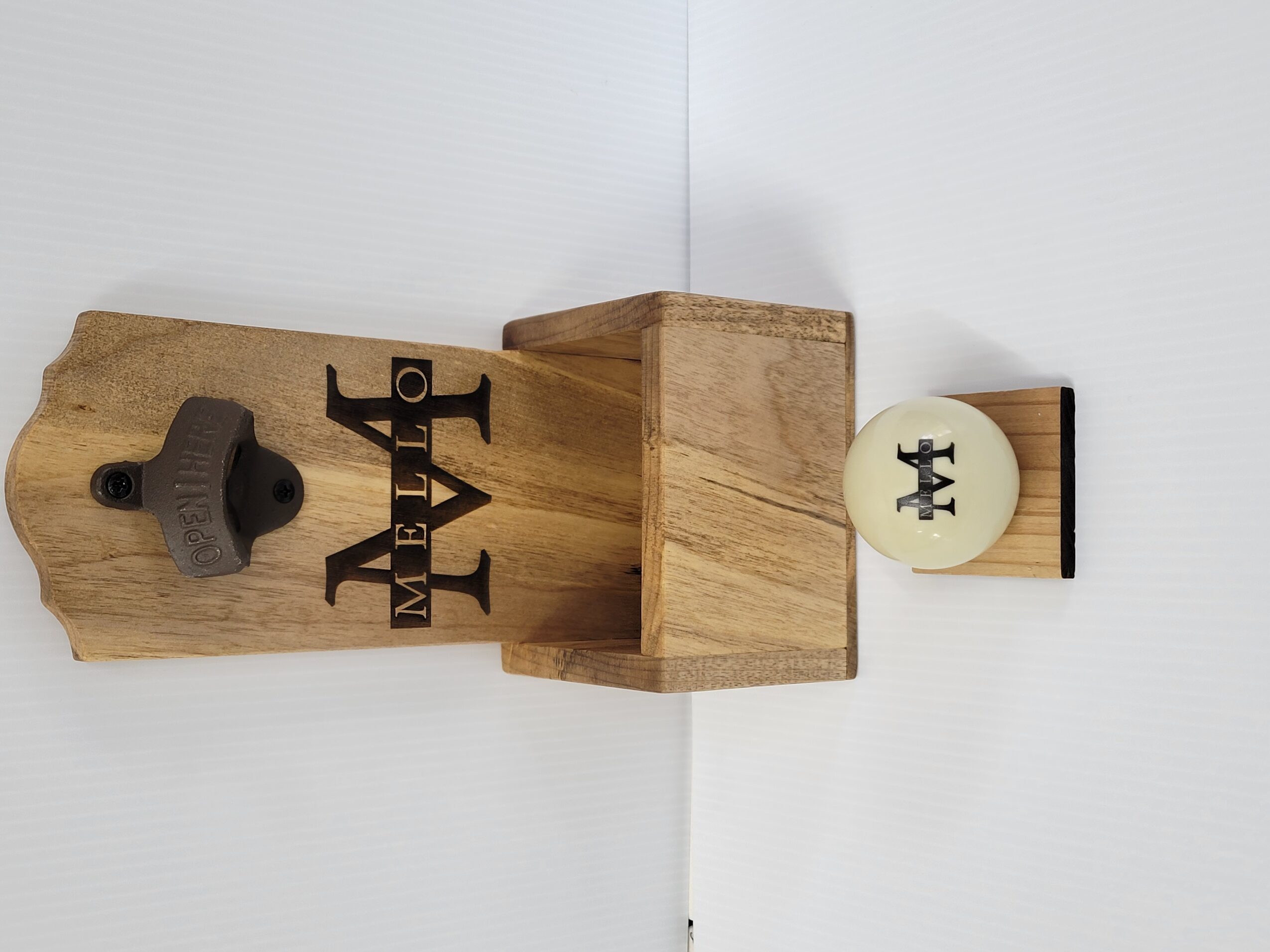 Wooden block with a small white disc and black logo, placed on a white surface.