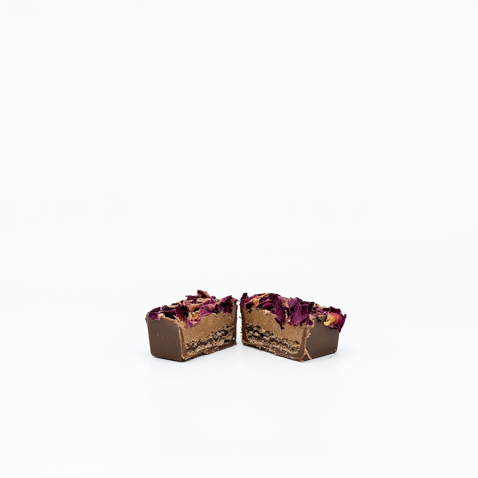 Two halves of a chocolate dessert with berry topping on a white background.