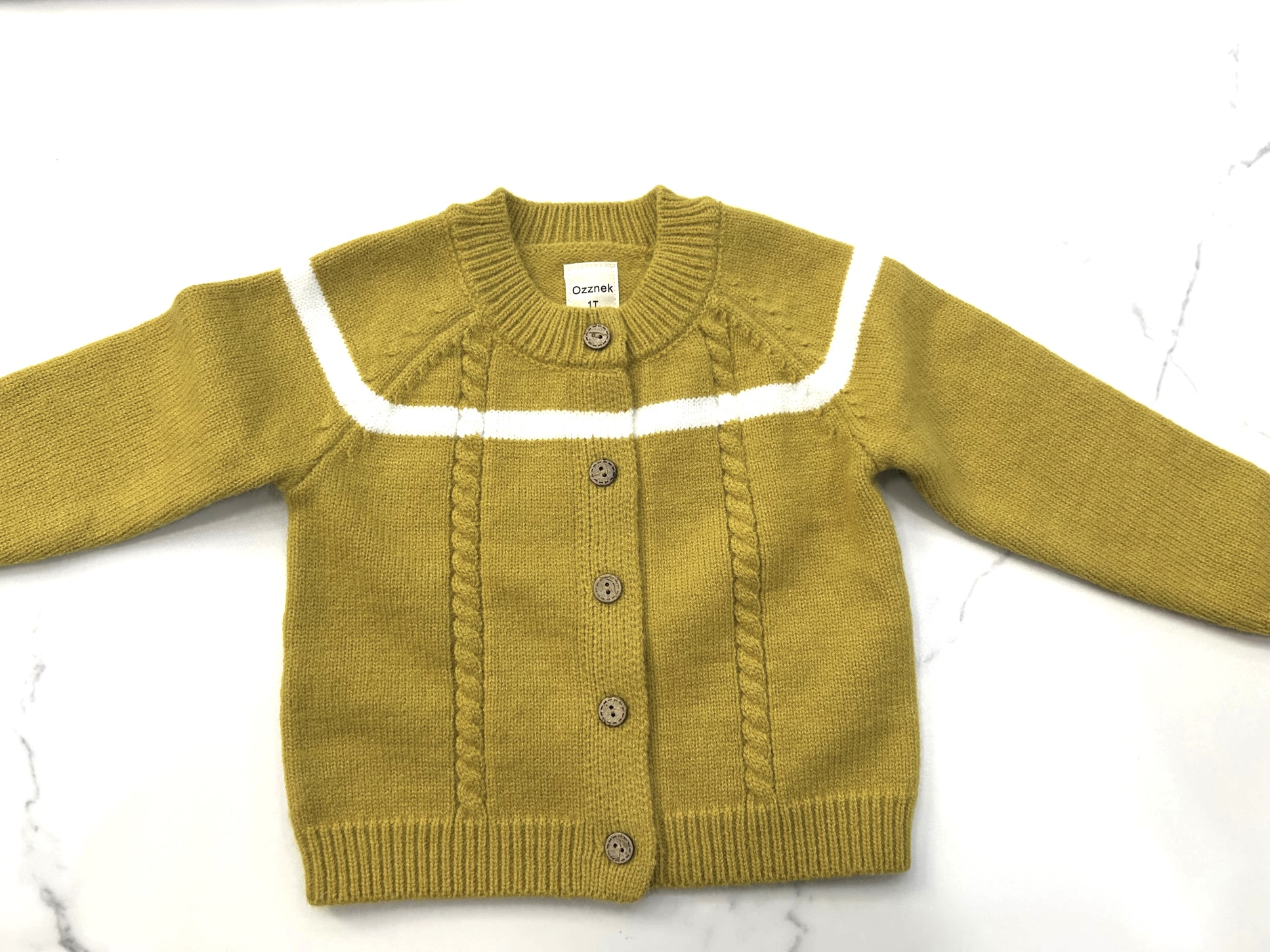 Yellow cardigan with white trim, buttoned front, and long sleeves, laid flat on a white surface.