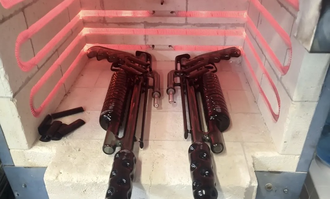 Two guns are placed inside a glowing red-lit enclosure with a white base and a metal wall on the left.
