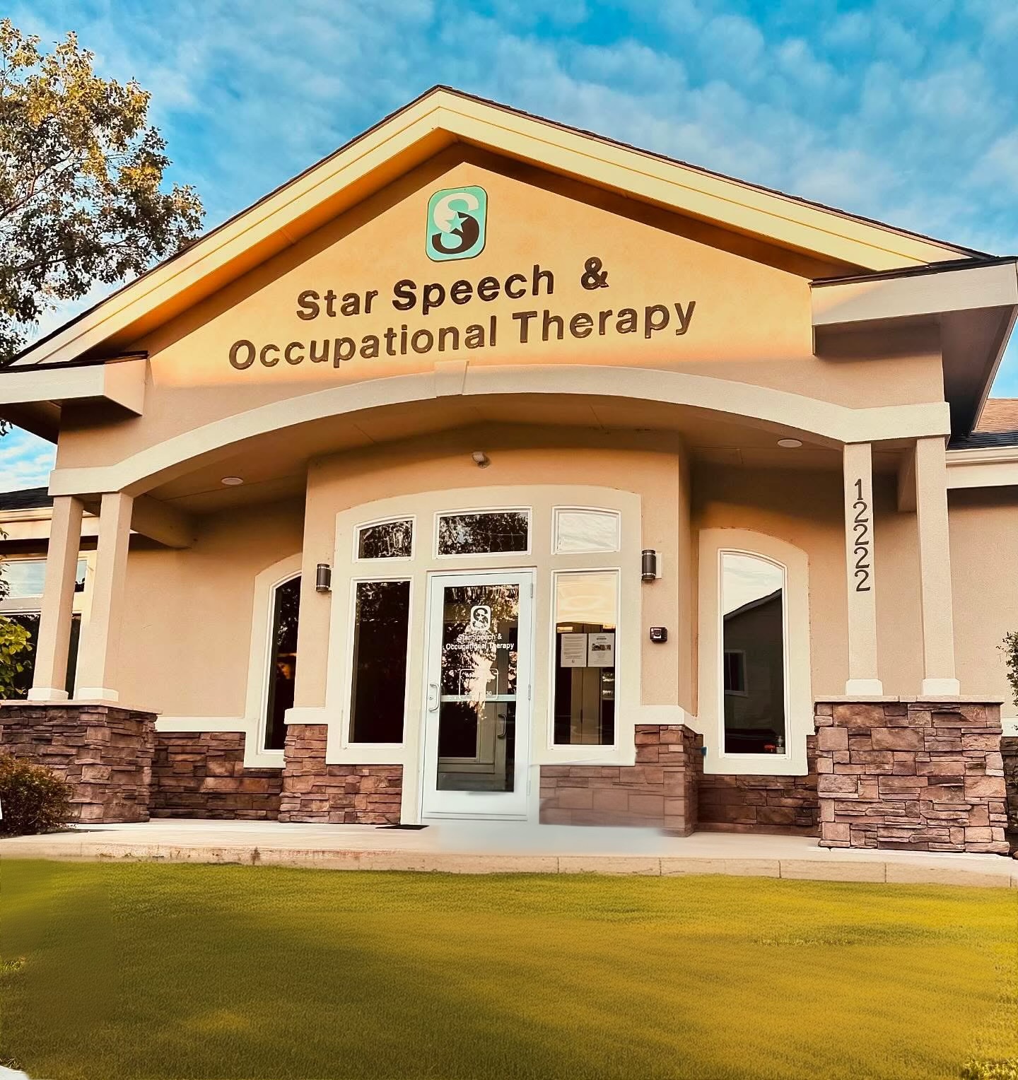 Building with sign reading 'Star Speech & Occupational Therapy' under a blue sky, with a lawn in front.