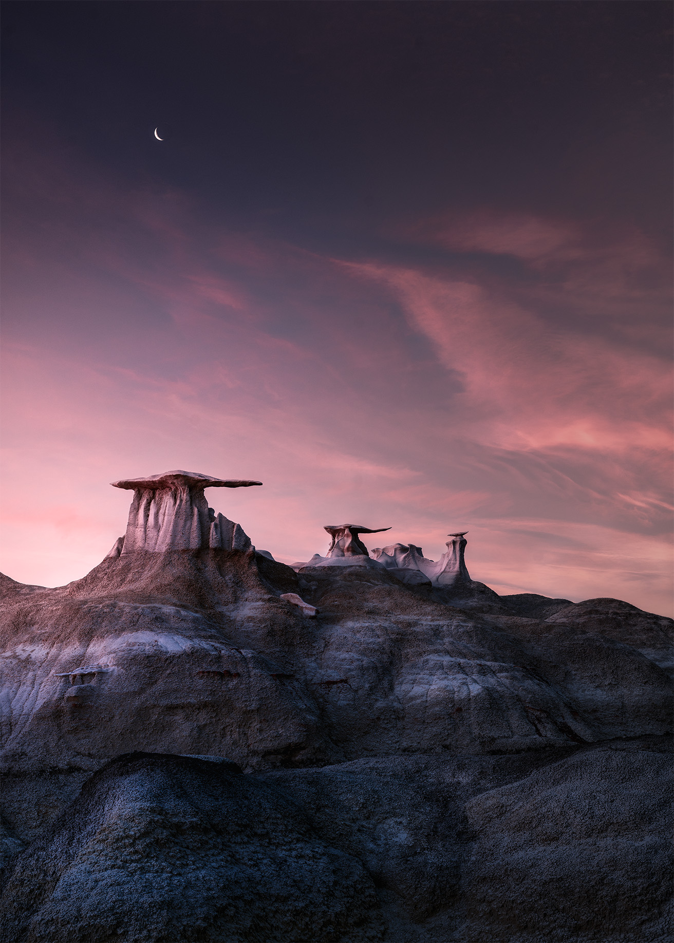 Landscape with rock formations under a pink and purple sky, with a visible star or planet, and dark foreground.