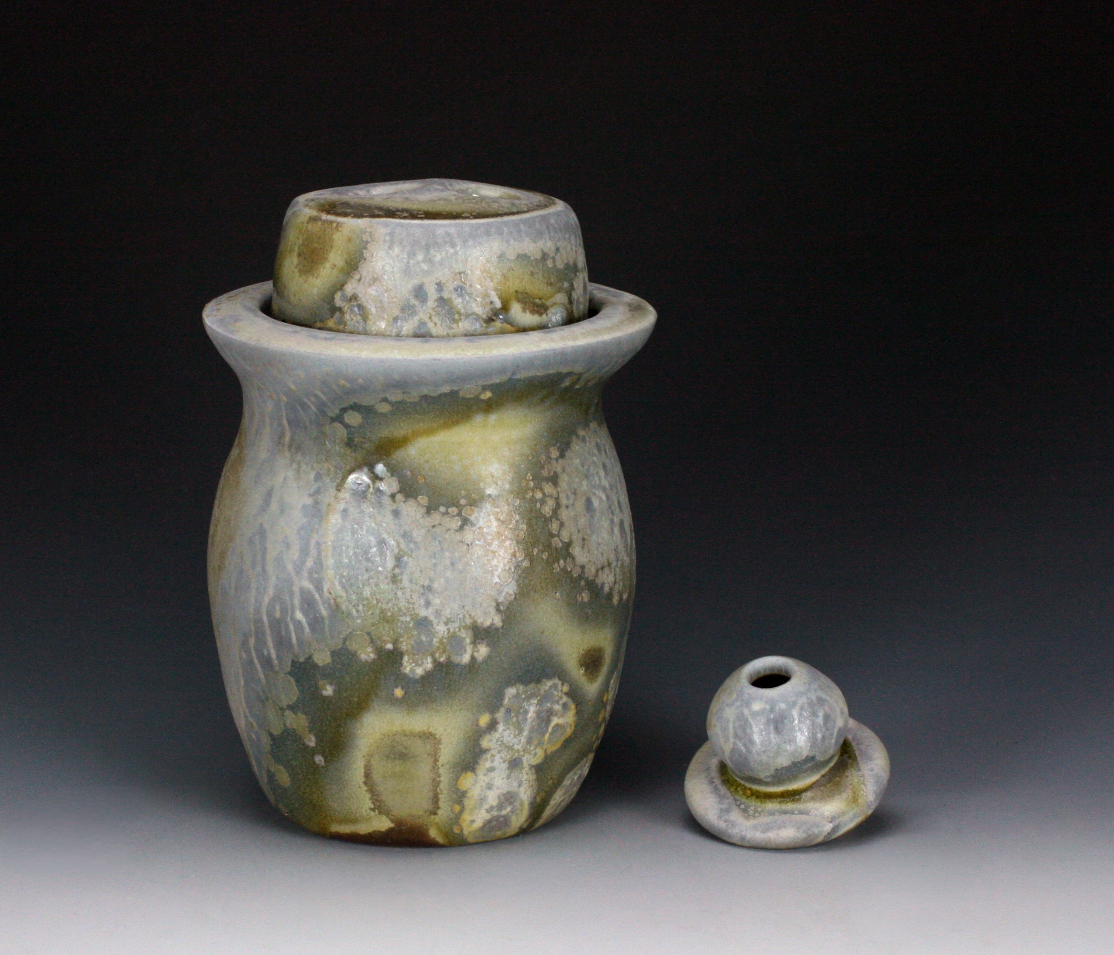 Two ceramic vessels, one large with a wide opening and one small with a narrow opening, both with a mottled glaze.