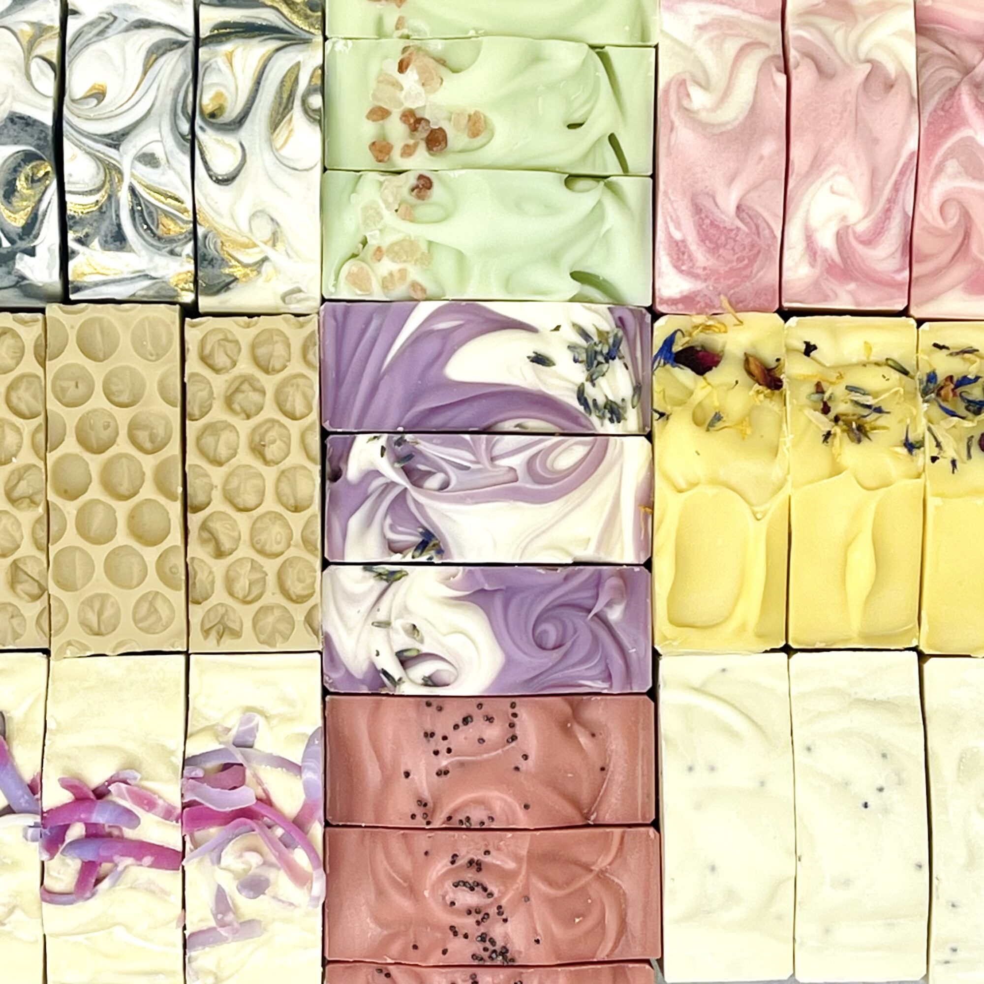 Colorful soap bars with swirled patterns in various pastel shades arranged in a grid.