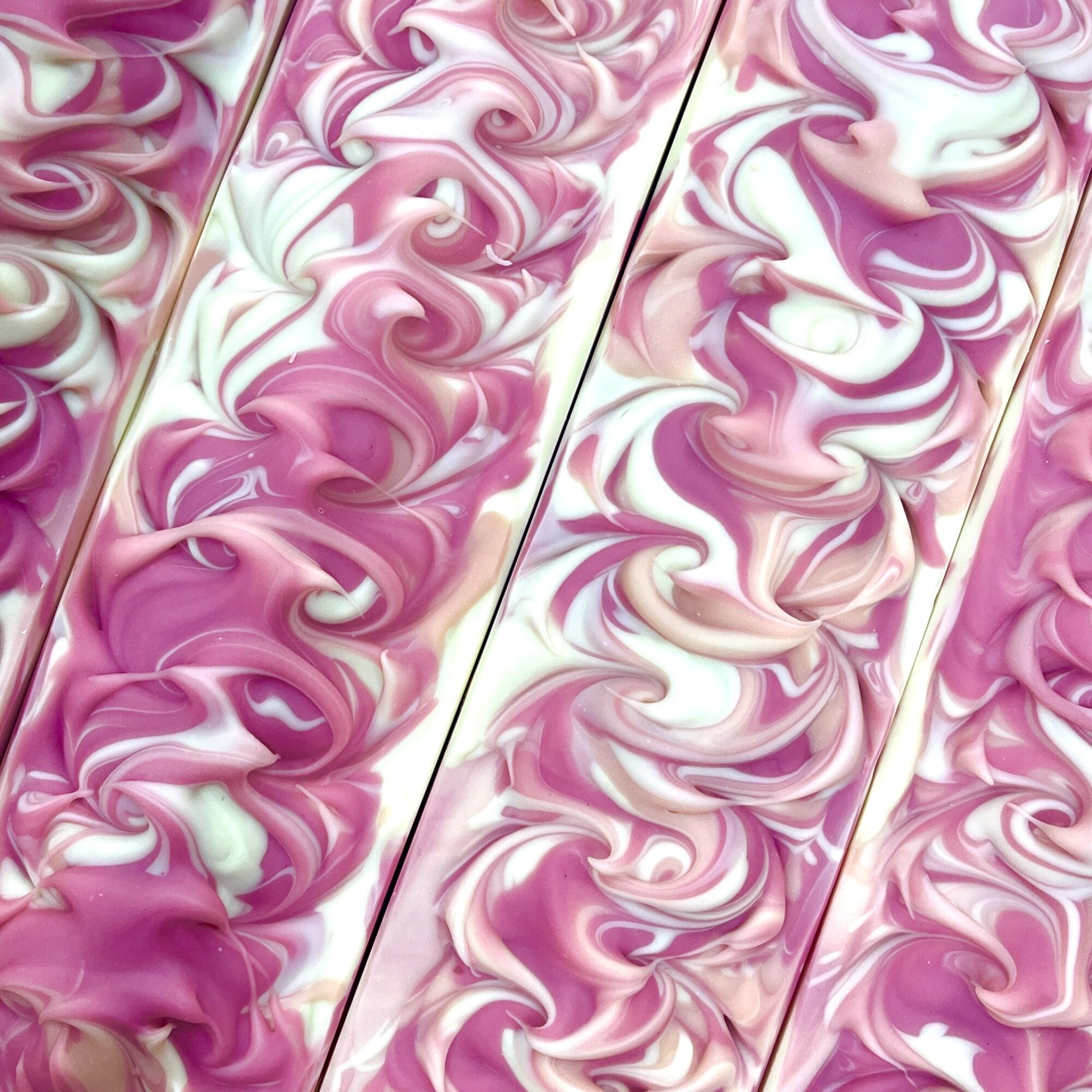 Close-up of pink and white marbled patterns on a surface, with four vertical sections showing swirling designs.