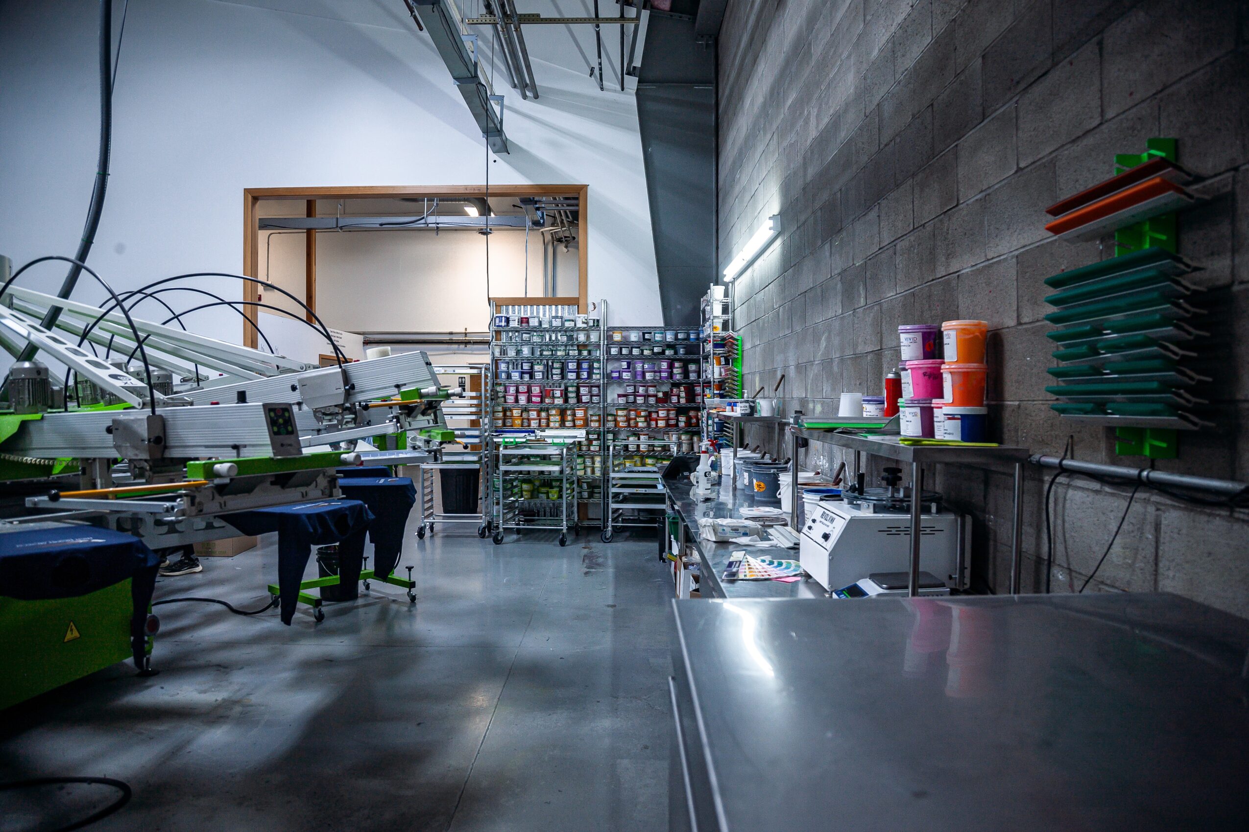 Laboratory with equipment, shelves, and supplies along a gray wall, viewed from a low angle.