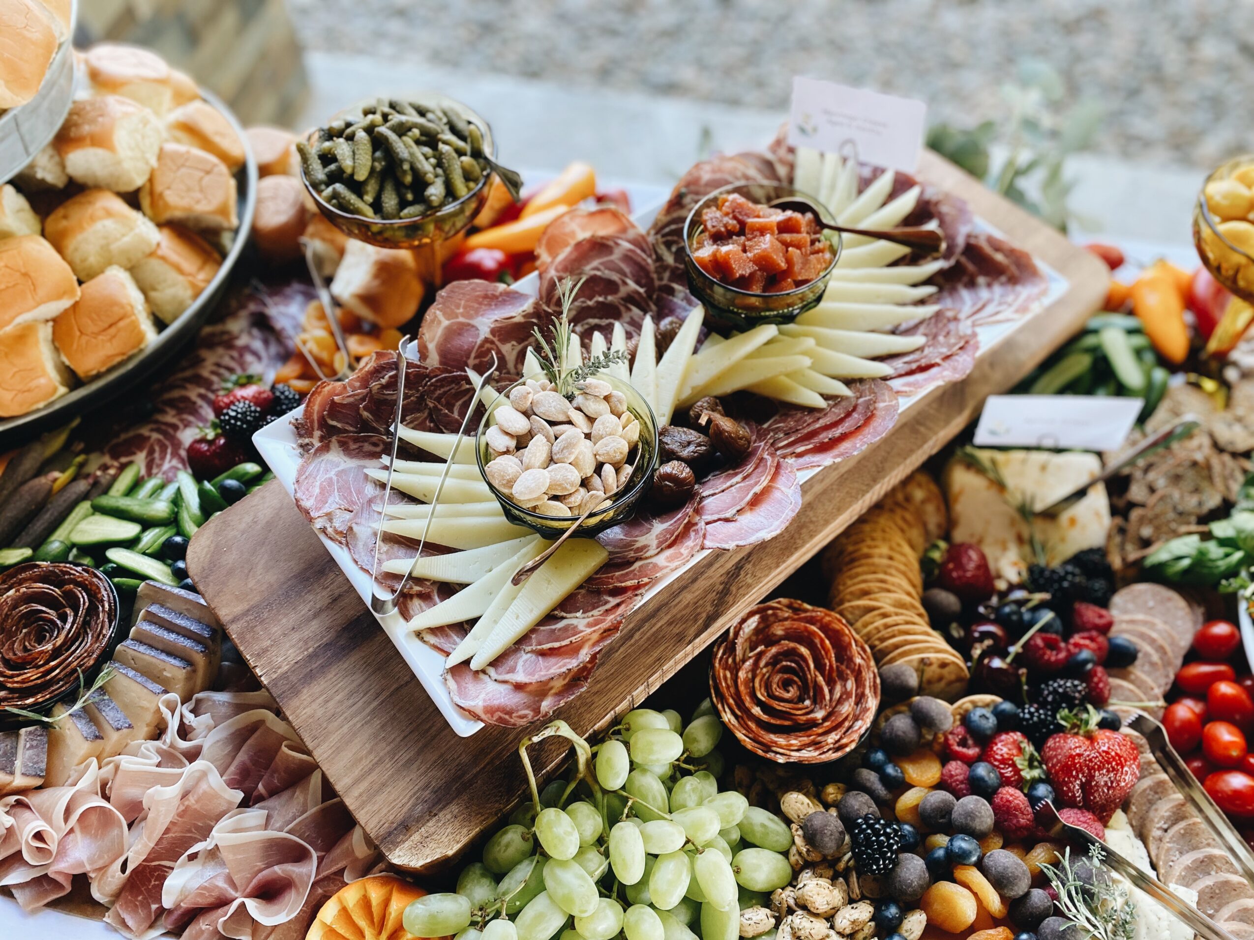 Assorted cheeses, fruits, and snacks arranged on a table for a buffet or party spread.