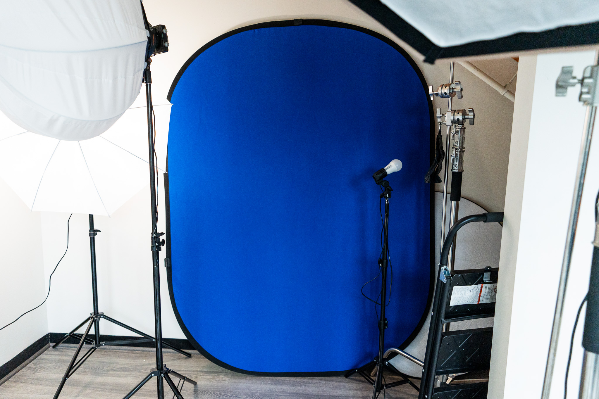 Blue collapsible backdrop with lighting equipment in a photography studio.