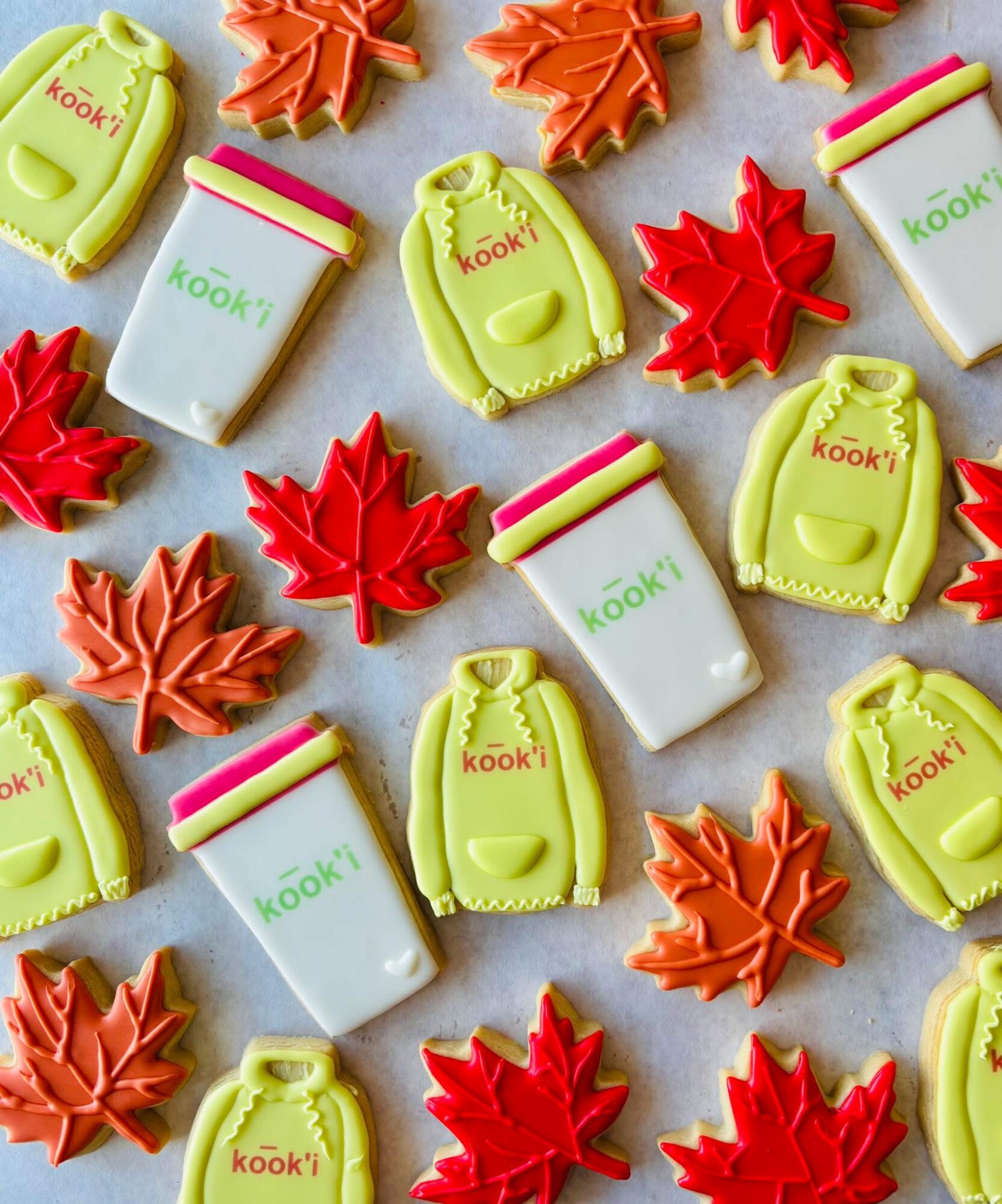 Colorful autumn-themed candies and maple leaf-shaped decorations on a light background.