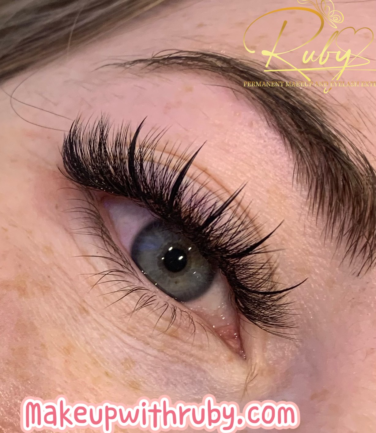 Close-up of a person's eye with long, thick eyelashes and well-groomed eyebrow, with a pink background and text overlay.