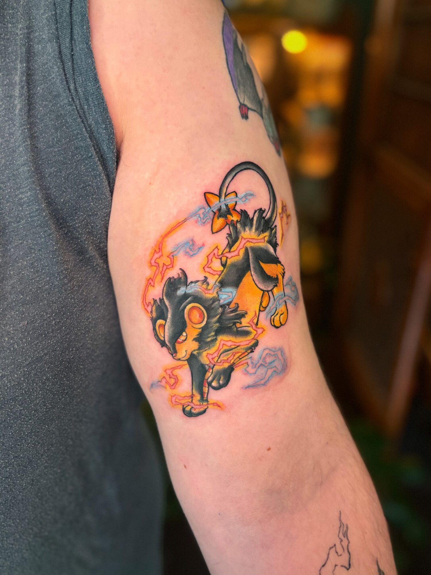 Tattoo of two characters from Dragon Ball, Goku and Vegeta, in a fiery scene with bright colors and dynamic poses.