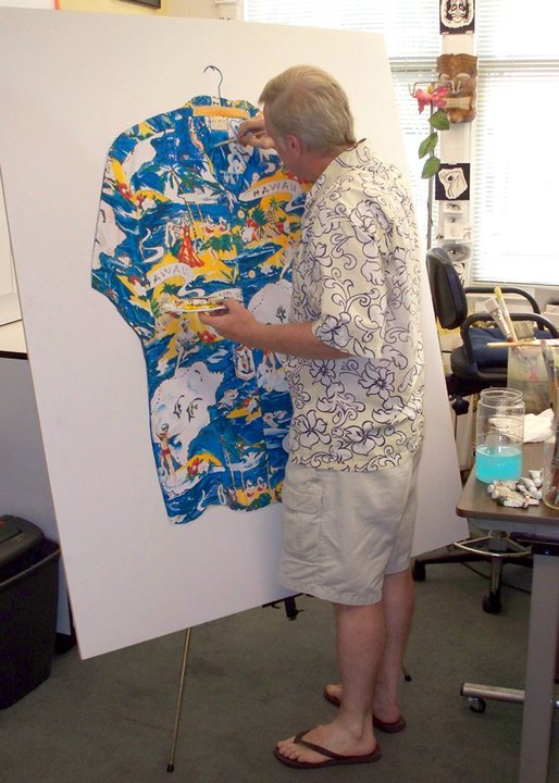 Person with short hair and glasses examines a colorful painting of a dress on a whiteboard in an office.
