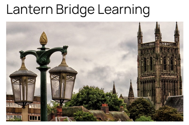 Street lamp with two lanterns in front of a historic church tower and trees, with text 'Lantern Bridge Learning' above.
