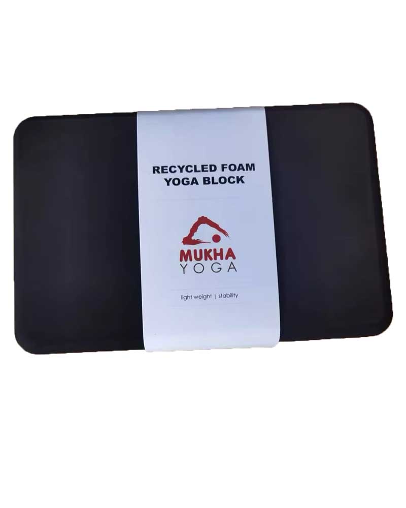 Black recycled foam yoga block with a white label in the center, displaying text and logo.