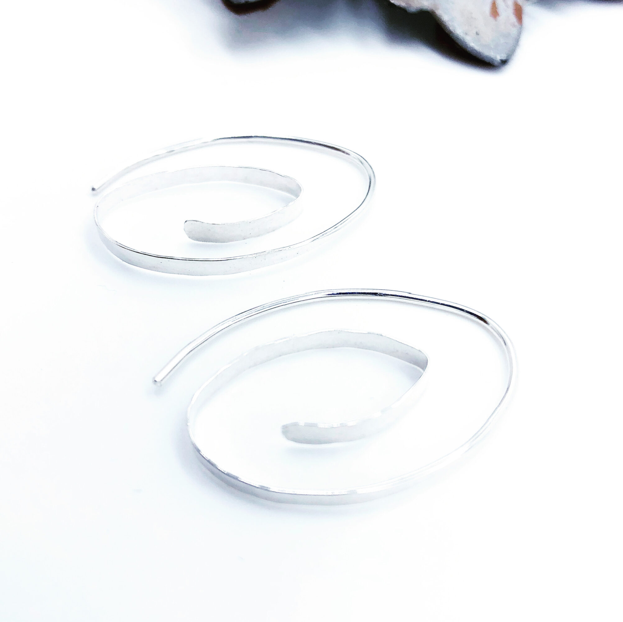 Two transparent, curved plastic objects on a white surface with a blurred background, possibly part of a device or accessory.