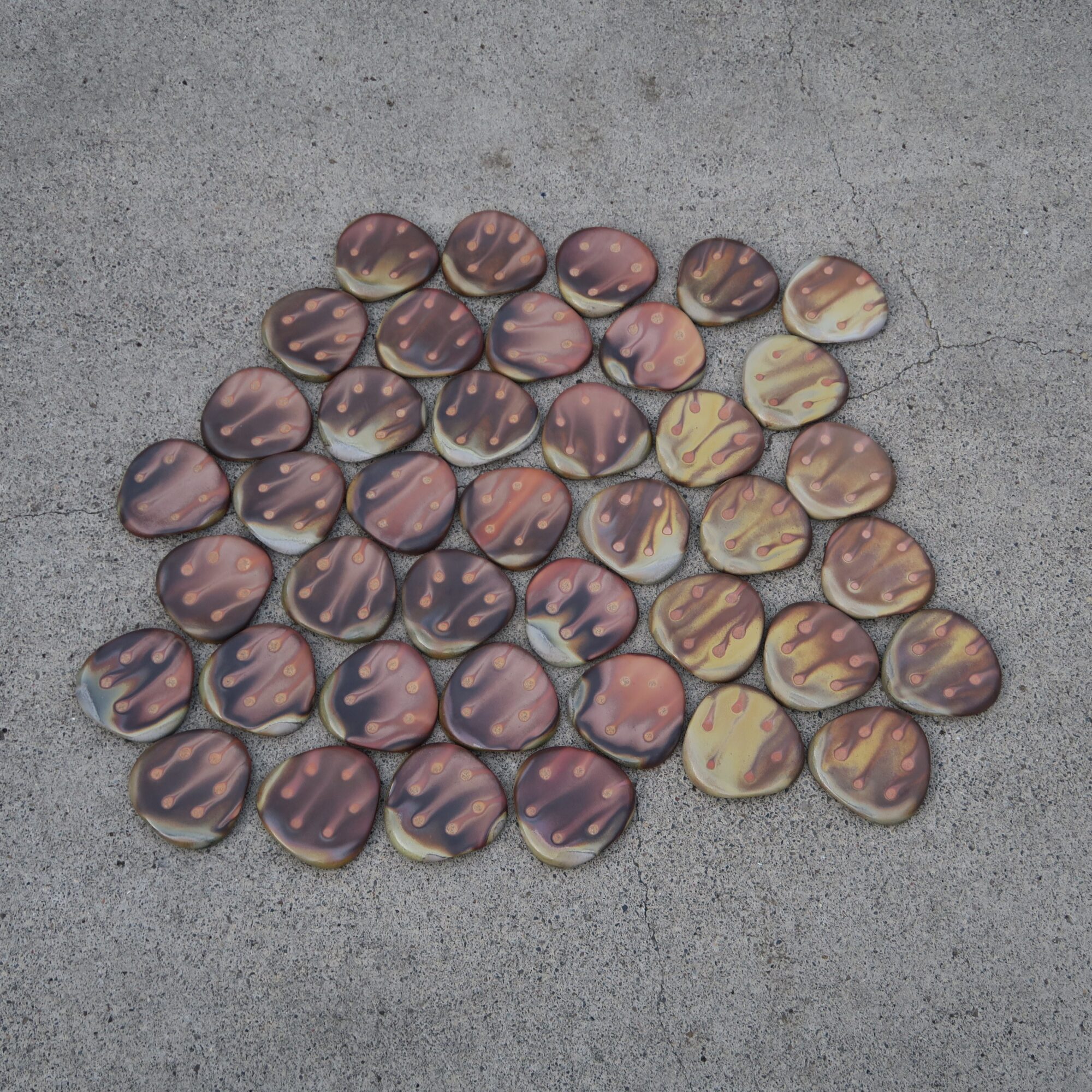 Multiple chocolate candies with striped patterns arranged on a gray surface.