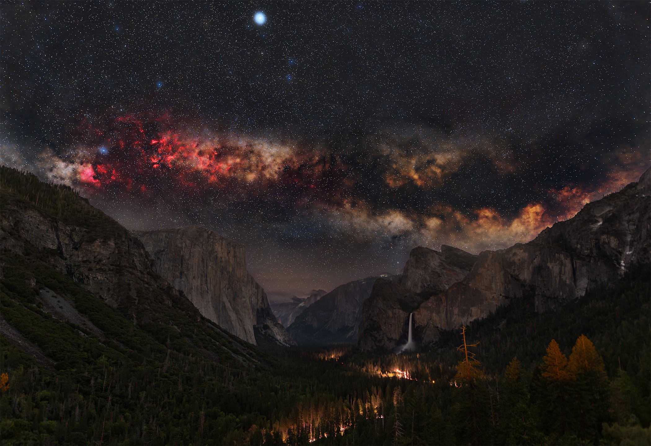Night sky with stars and Milky Way over mountains and valley, landscape view, dark and starry.