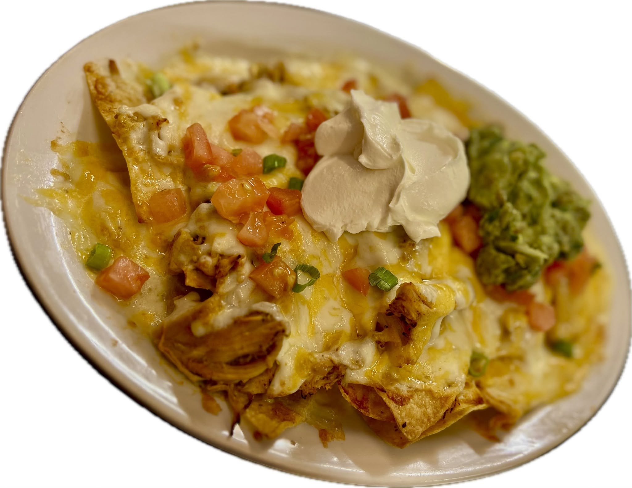 Baked dish with cheese, vegetables, sour cream, and guacamole on a white oval plate.