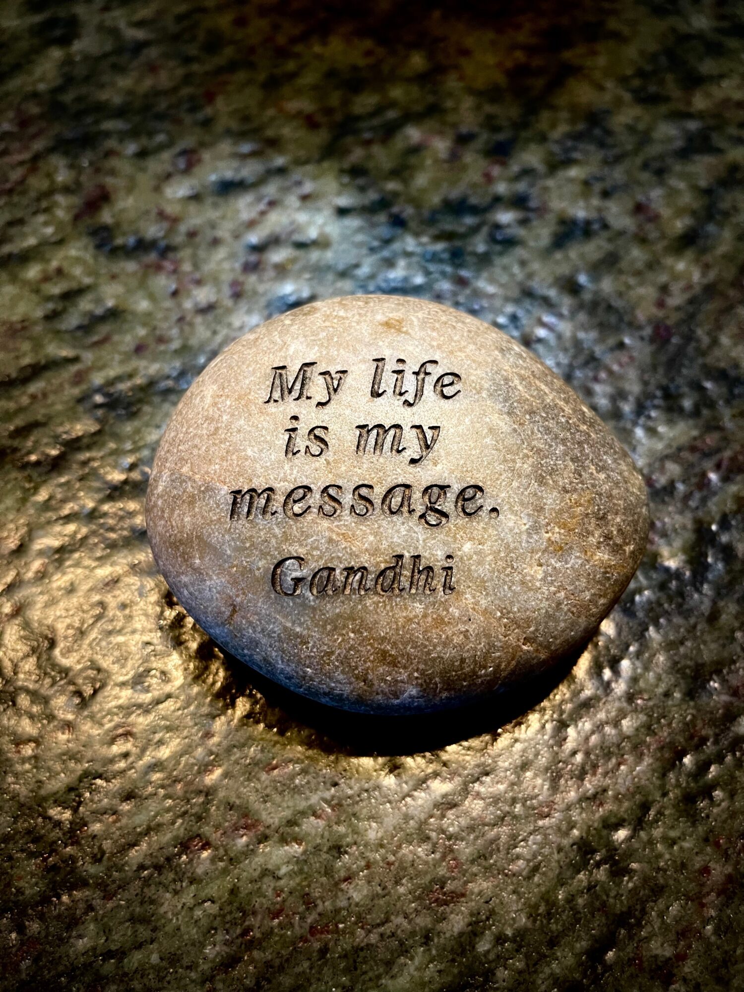 A smooth stone with engraved text reading,