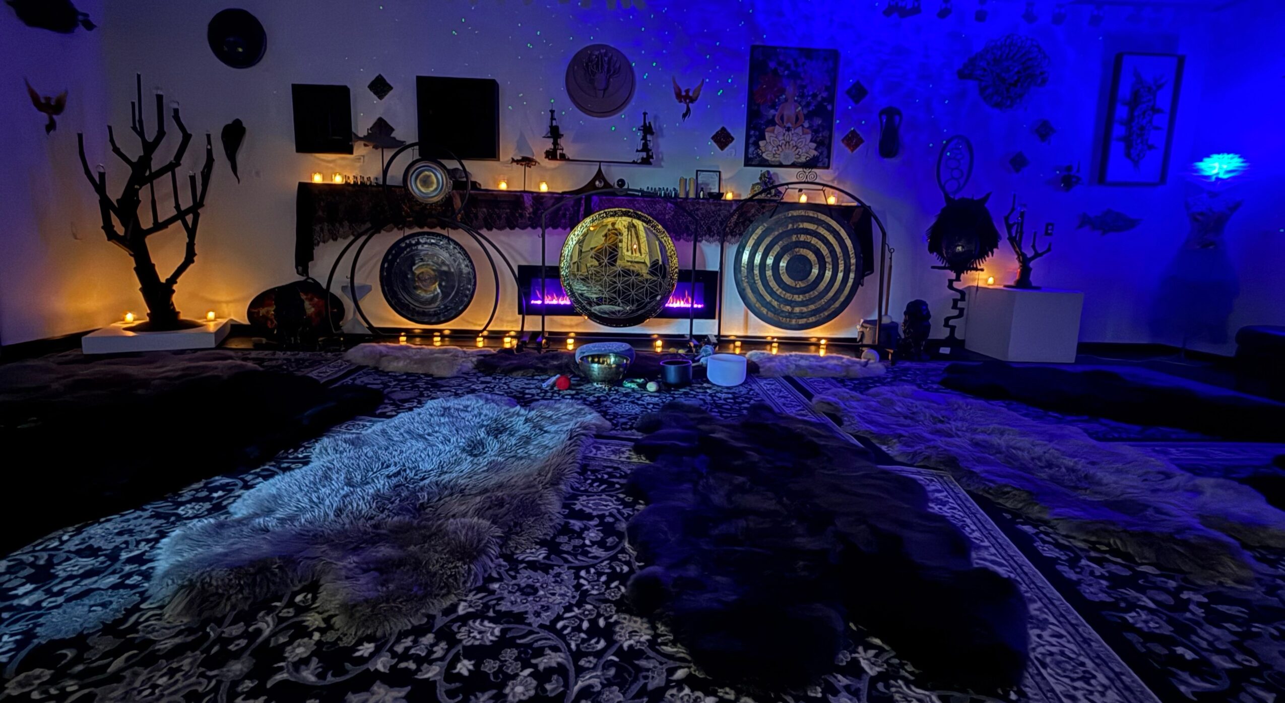 Room with cosmic and nature-themed decorations, glowing orbs, and blue lighting, with a textured blanket in the foreground.