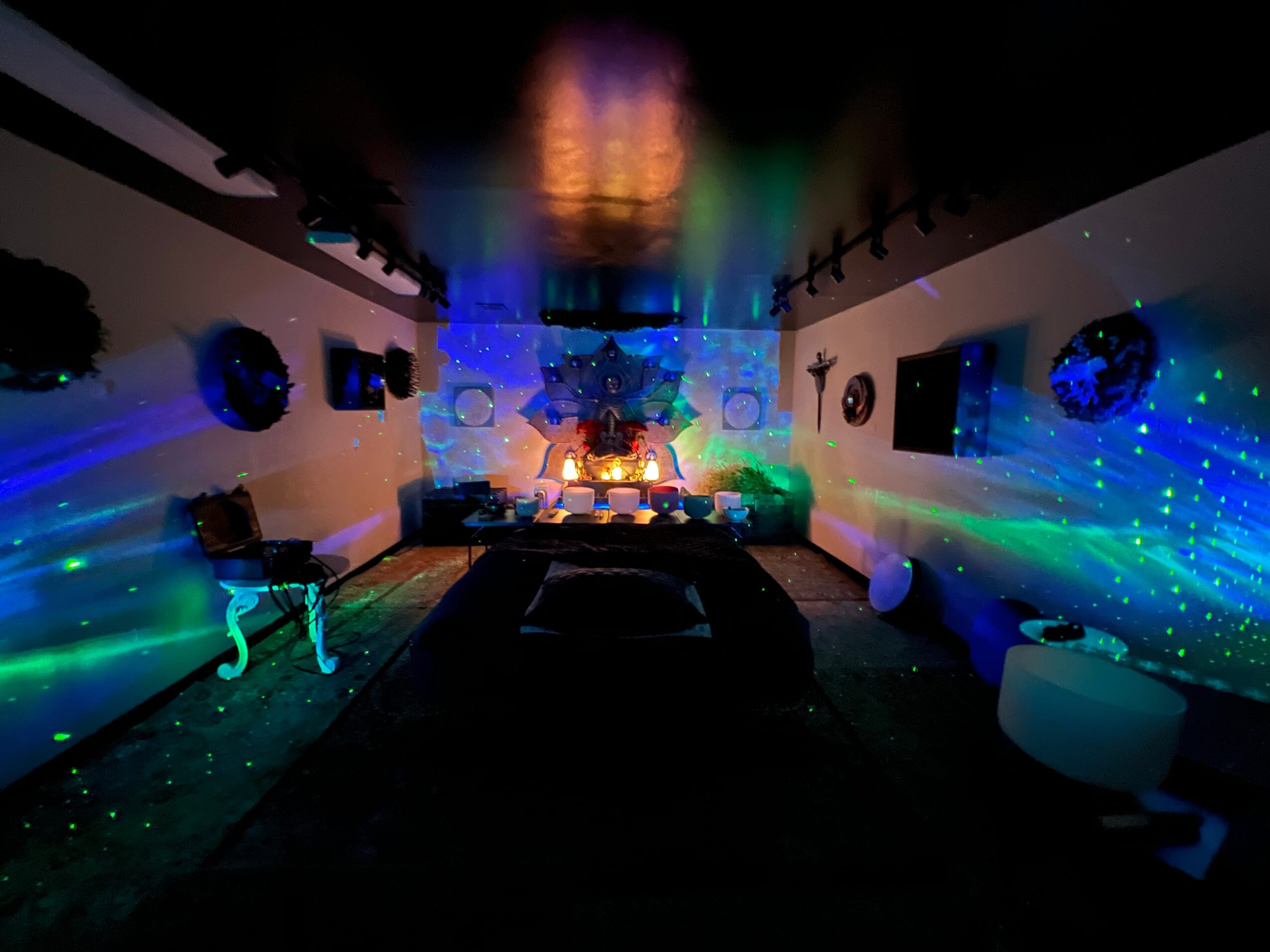 Room decorated with colorful lights, disco balls, and a central table with a glowing centerpiece, creating a party atmosphere.