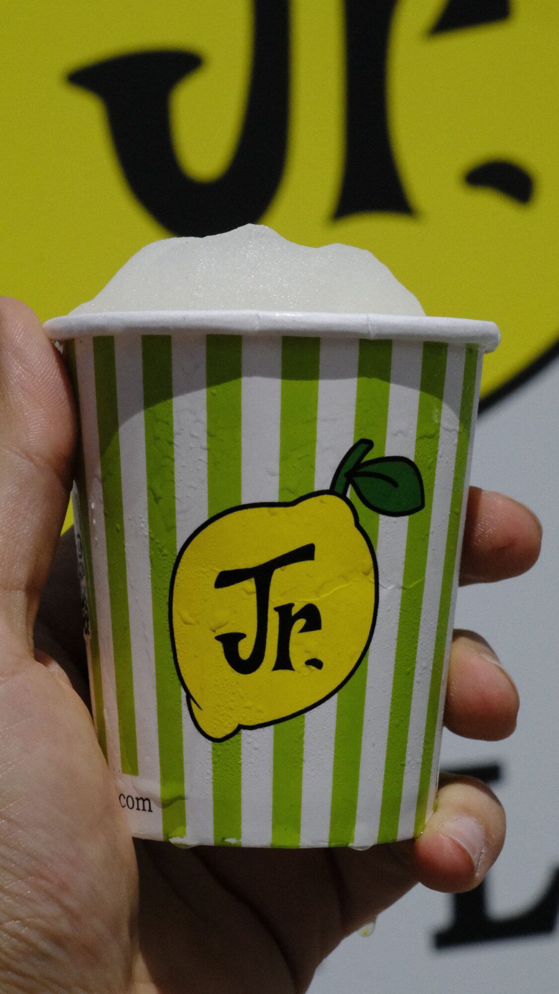 Person holding a lemon-shaped Juicy Fruit gum pack with green and white stripes, and a yellow lemon illustration.