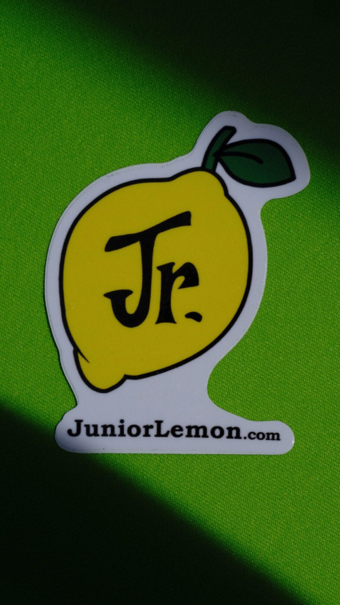 Logo with yellow lemon shape and black Jf letters, green background, website URL below, leaf attached to lemon.