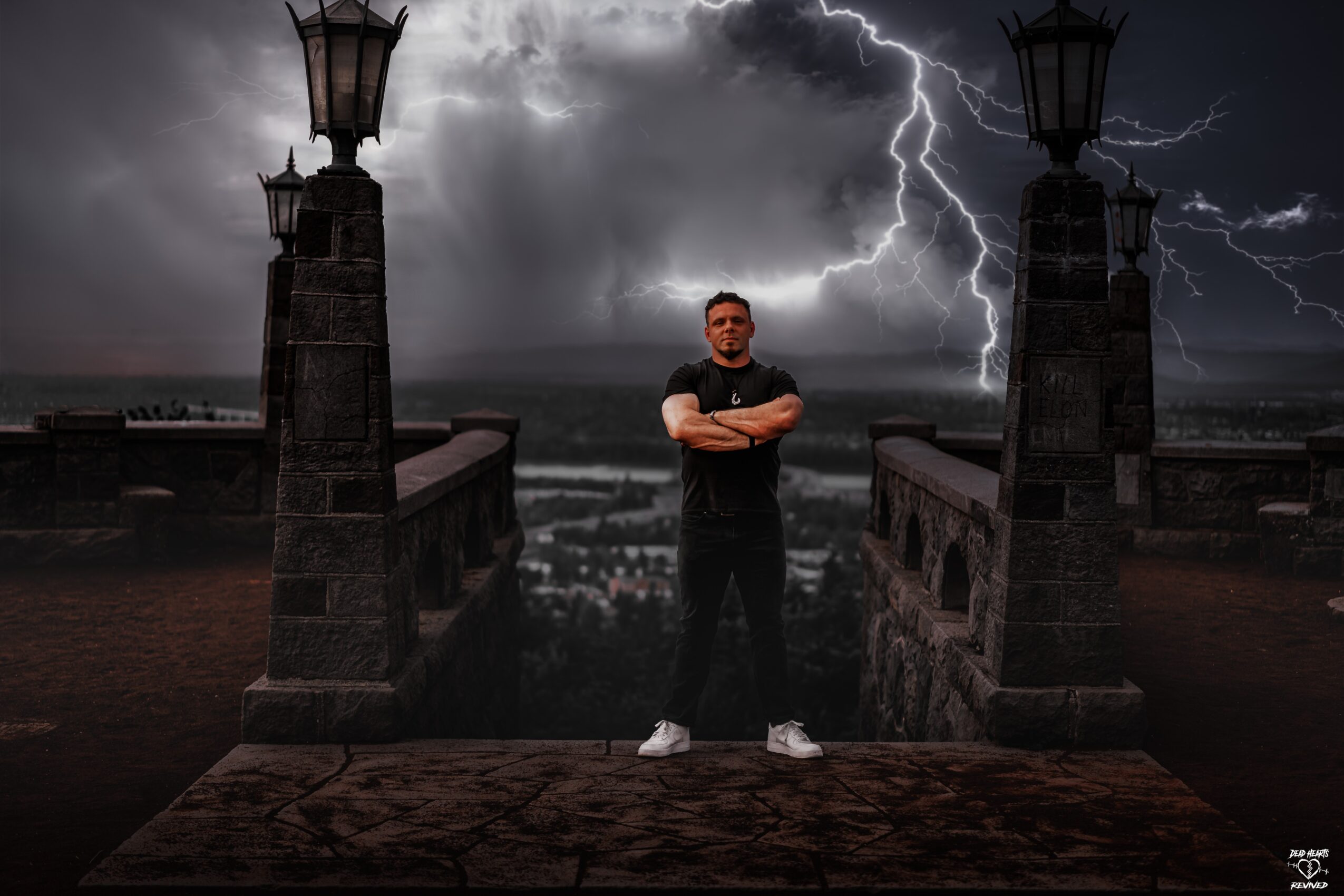 Person standing on a bridge with lightning in the stormy sky behind, arms crossed, dark clouds, and old lamp posts.