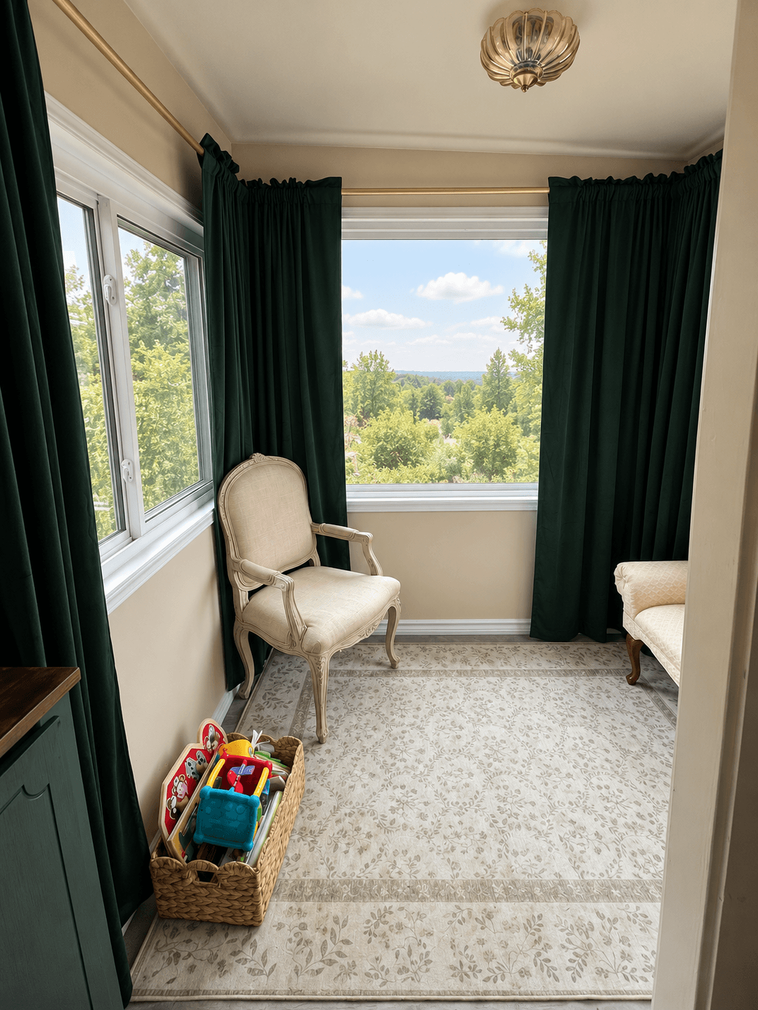Sunlit room with large window, green curtains, beige armchair, and a basket of toys, overlooking trees and sky.