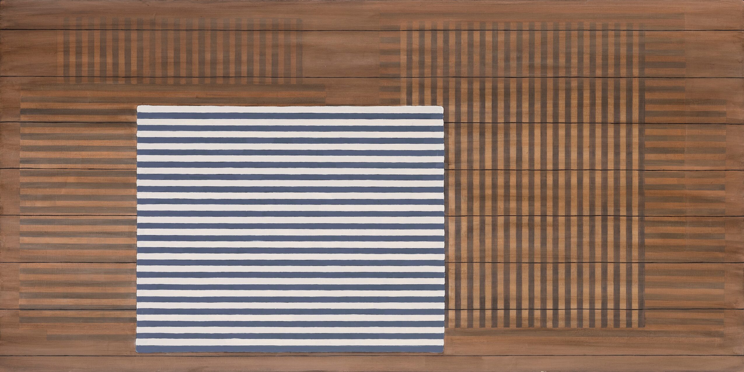 A striped fabric or mat on a wooden surface, with a partially visible grid pattern on the right side.