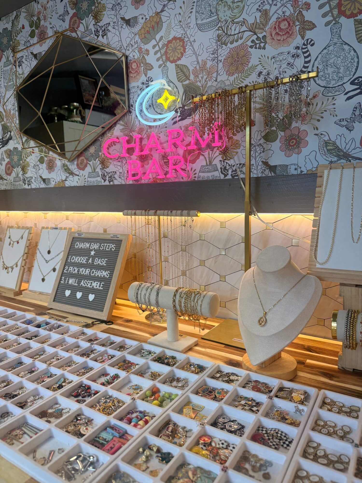 Display of jewelry with a mannequin bust, jewelry trays, and decorative elements in a store.