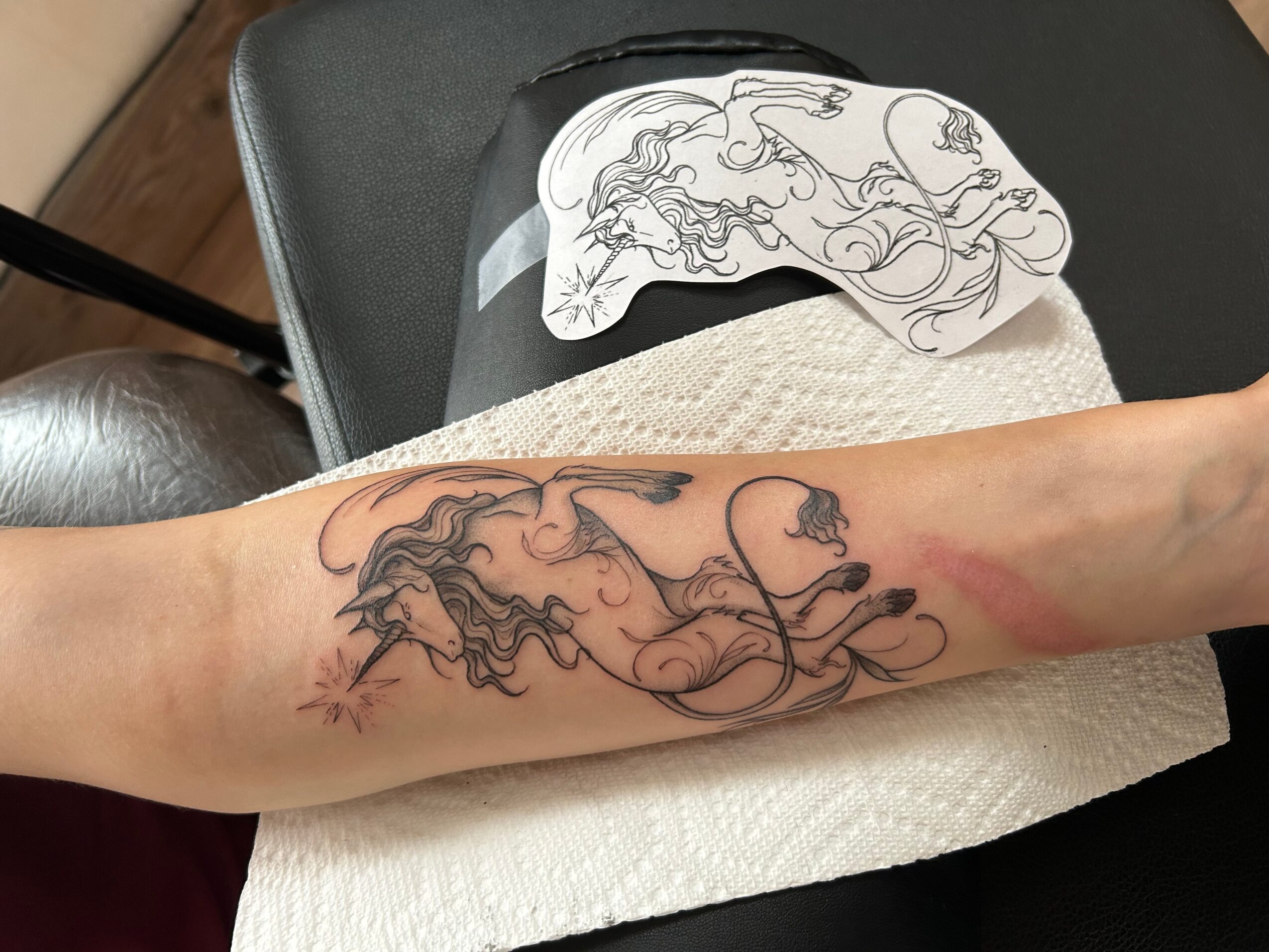 Forearm tattoo of a line drawing of a horse's head and flowing mane, with some shading and details.