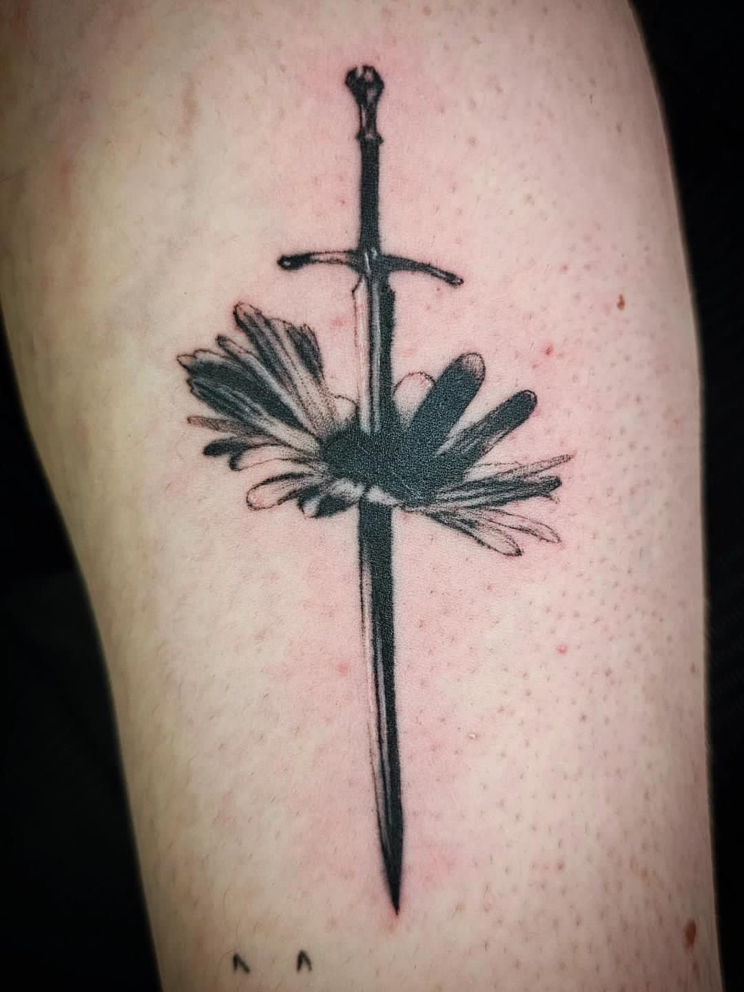 Tattoo of a sword with a butterfly in the middle, on skin with visible pores.