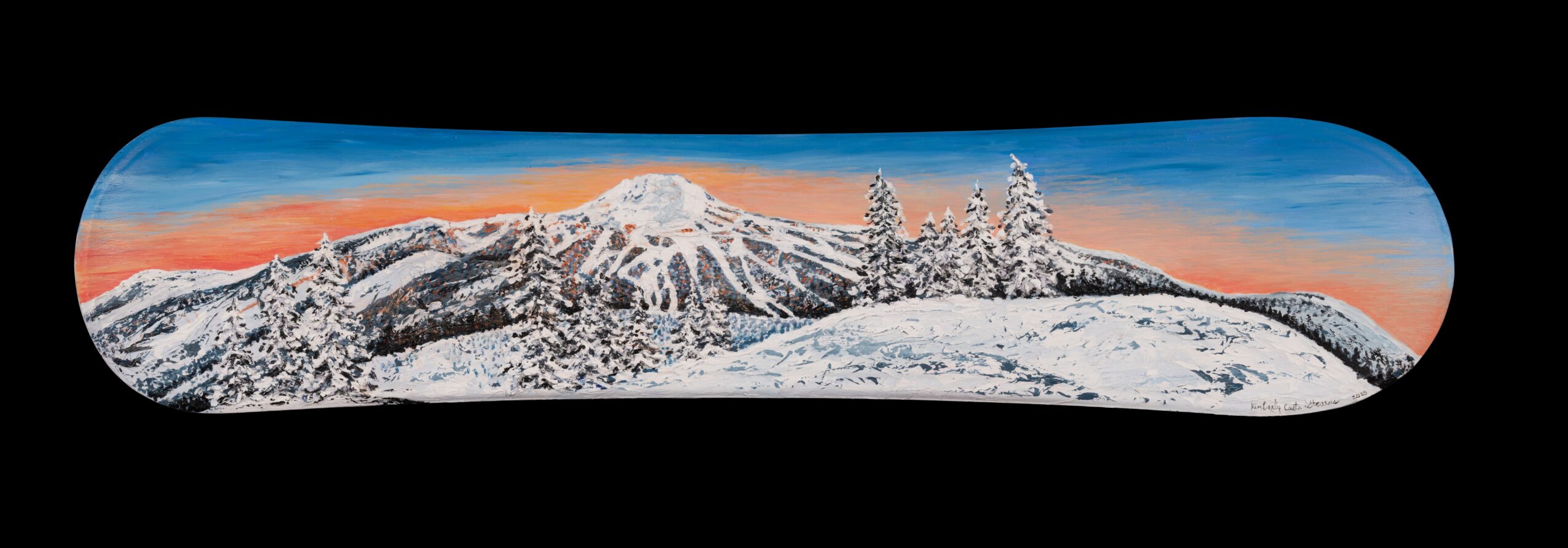 Panoramic view of snow-covered mountains with a colorful sky at sunrise or sunset, seen through a rounded rectangular window.