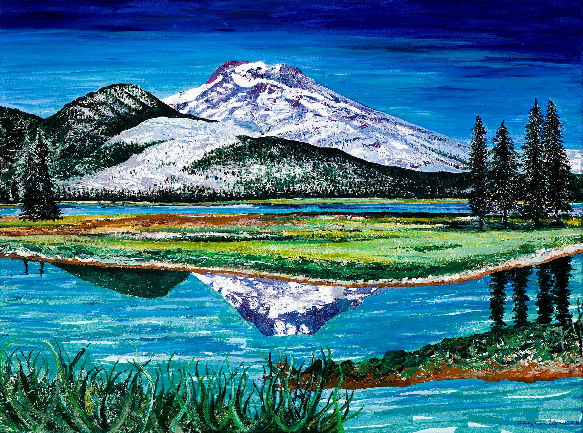 Snow-capped mountain with forest and lake reflection, green grass, and trees under a blue sky.