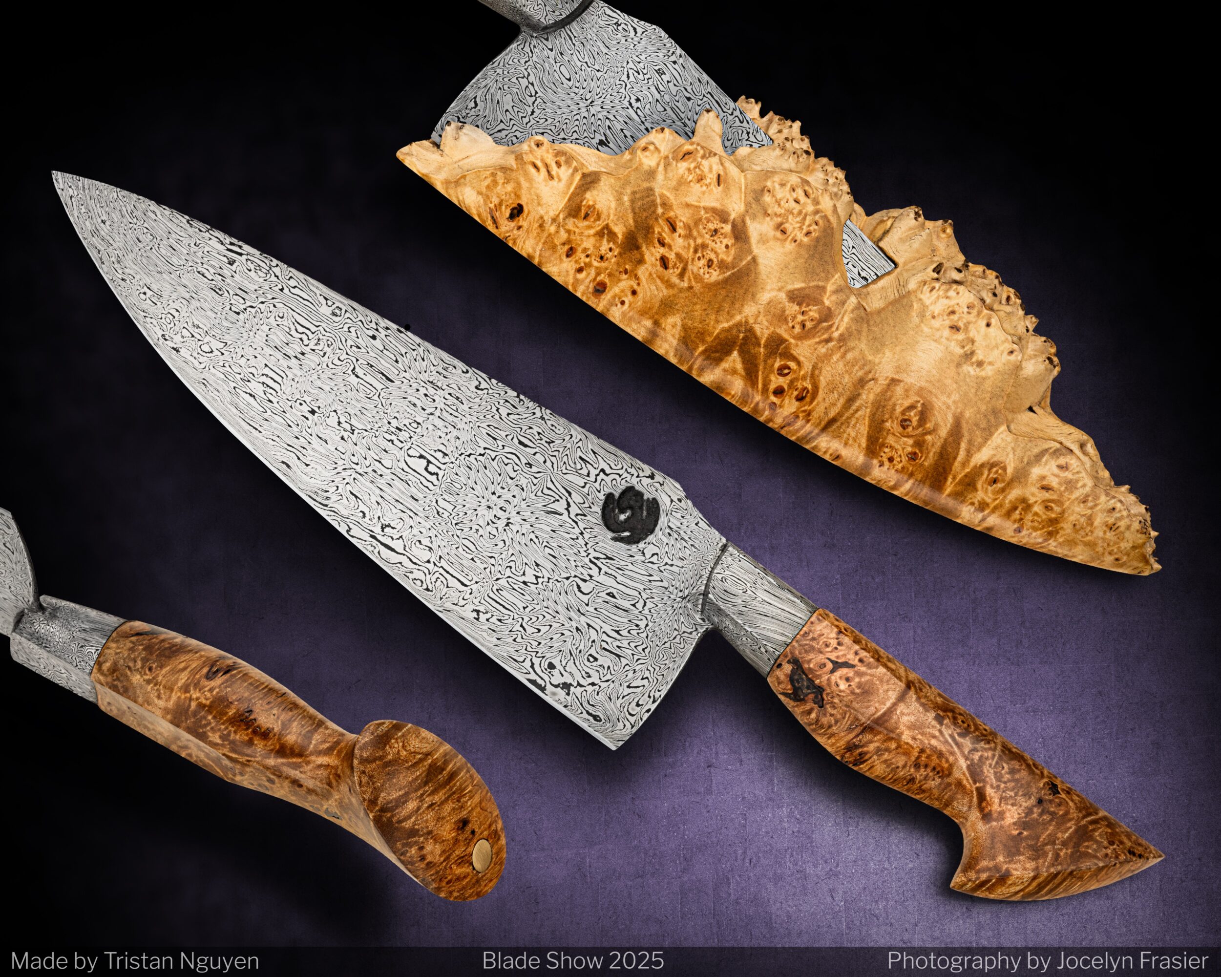 A large patterned kitchen knife with a wooden handle, a smaller knife, and a piece of wood with a textured surface on a dark background.