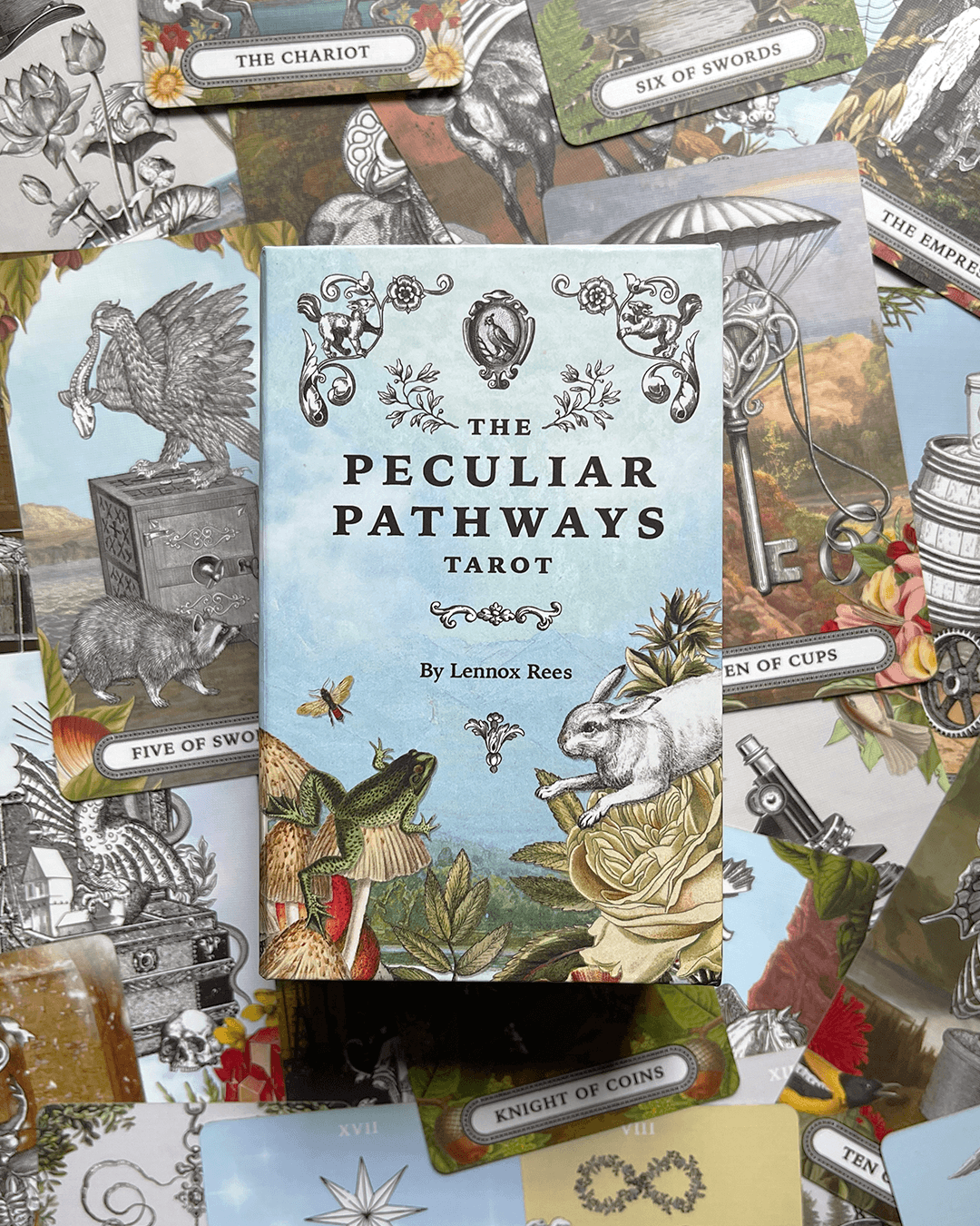 Deck of tarot cards with a central book titled 'The Peculiar Pathways Tarot' surrounded by various tarot cards and illustrations.