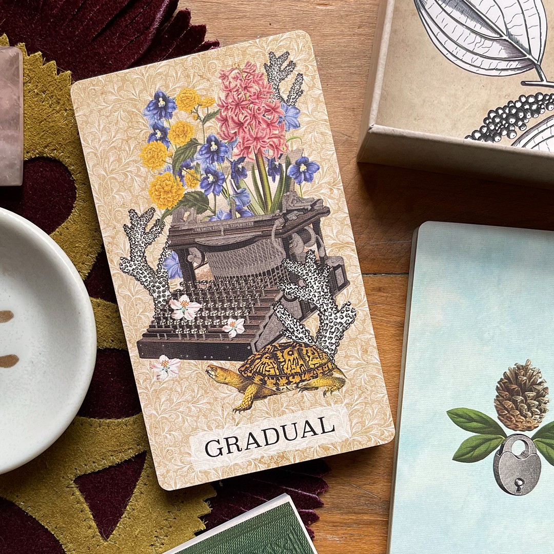 Decorative card with flowers, a turtle, and the word 'GRADUAL' on a wooden surface.