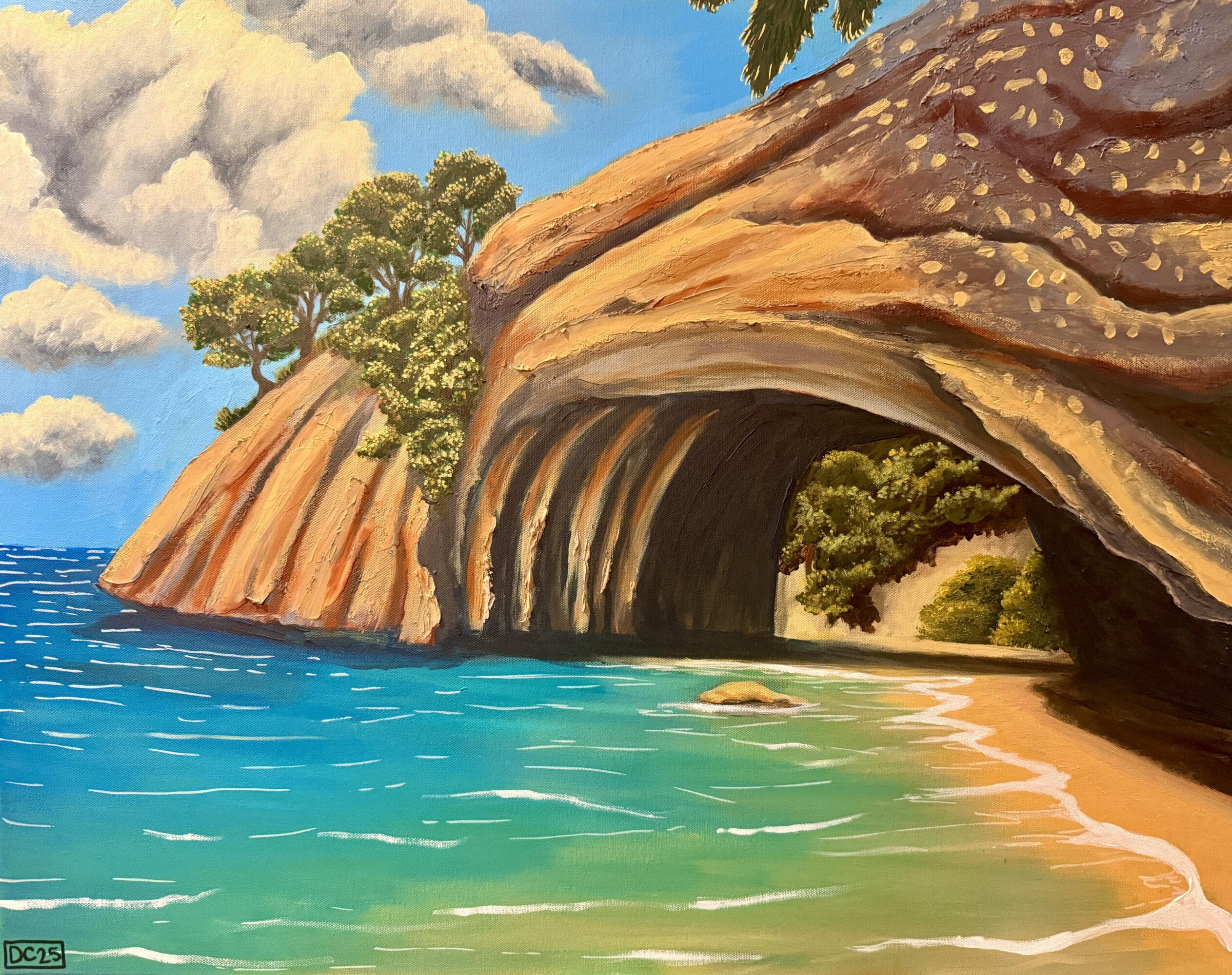 Coastal scene with rocky cliffs, trees, and a cave opening, with blue sky and clouds, and water in the foreground.