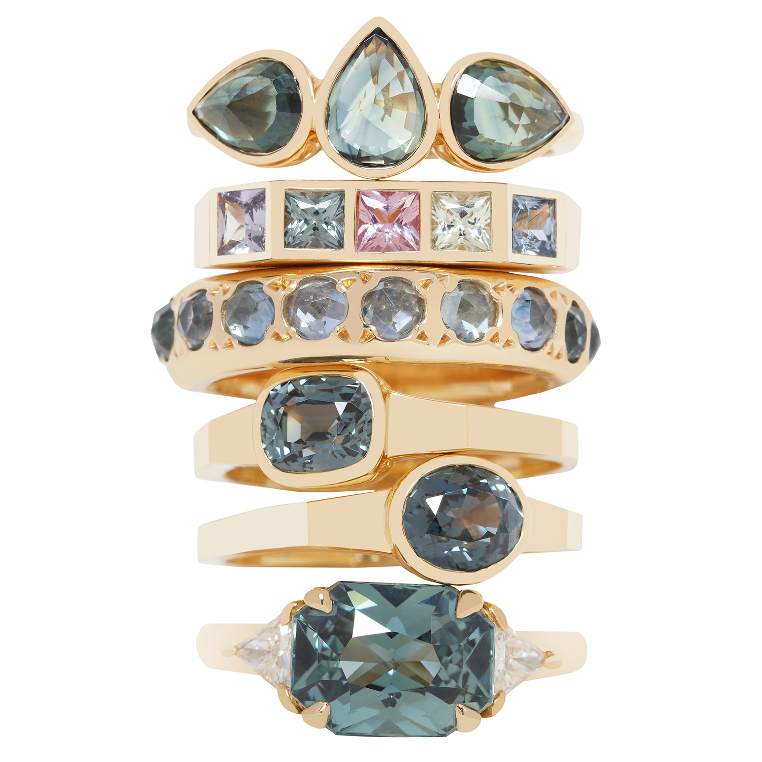 Stacked gold rings with various blue and pink gemstones, some with clear accents, arranged vertically against a white background.